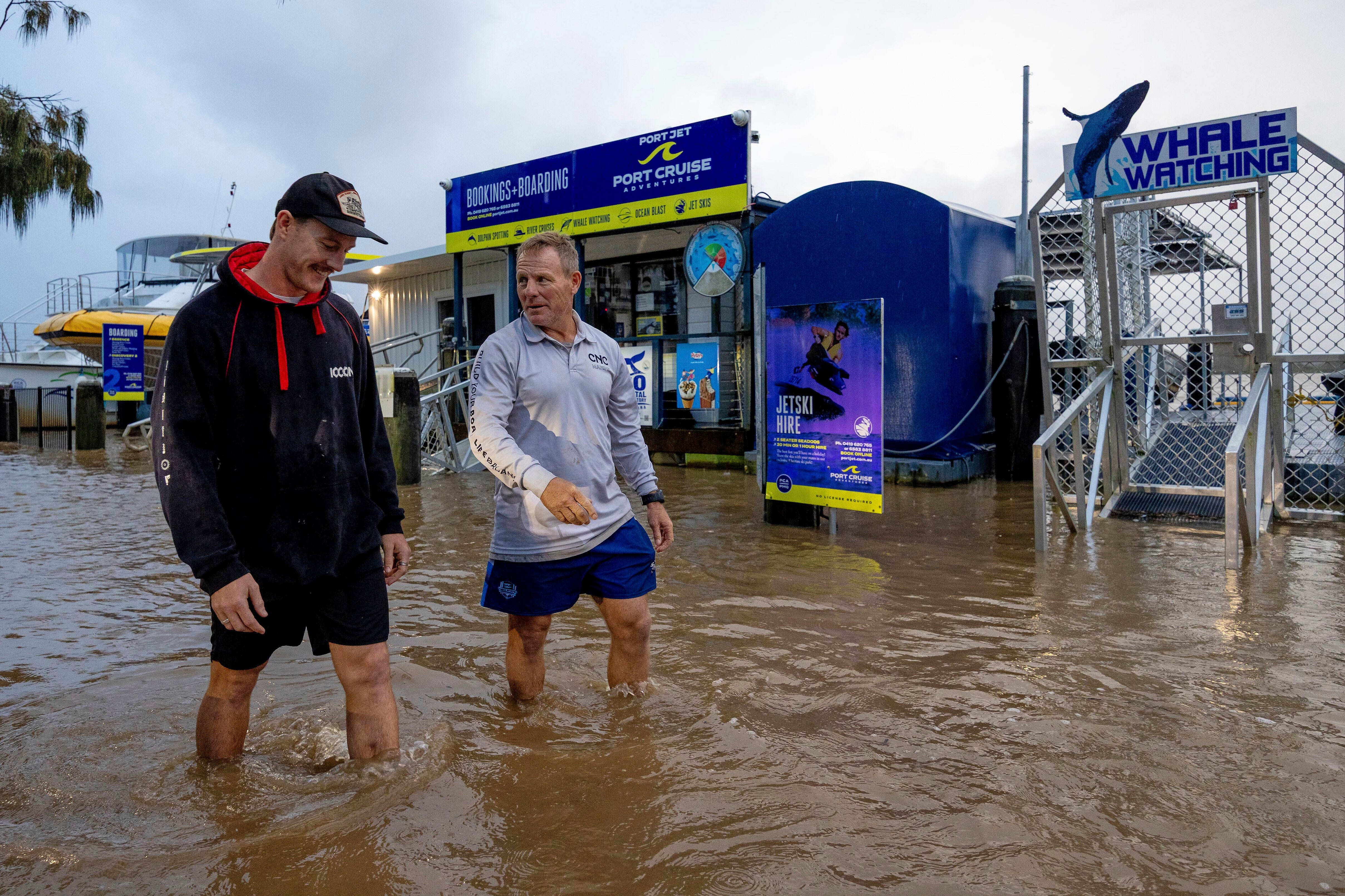Conor Lang i Anthony Heeney prolaze poplavljena područja u Port Macquarie, sjeverno od Sydneya, Australija, srijeda, 21. svibnja 2025.