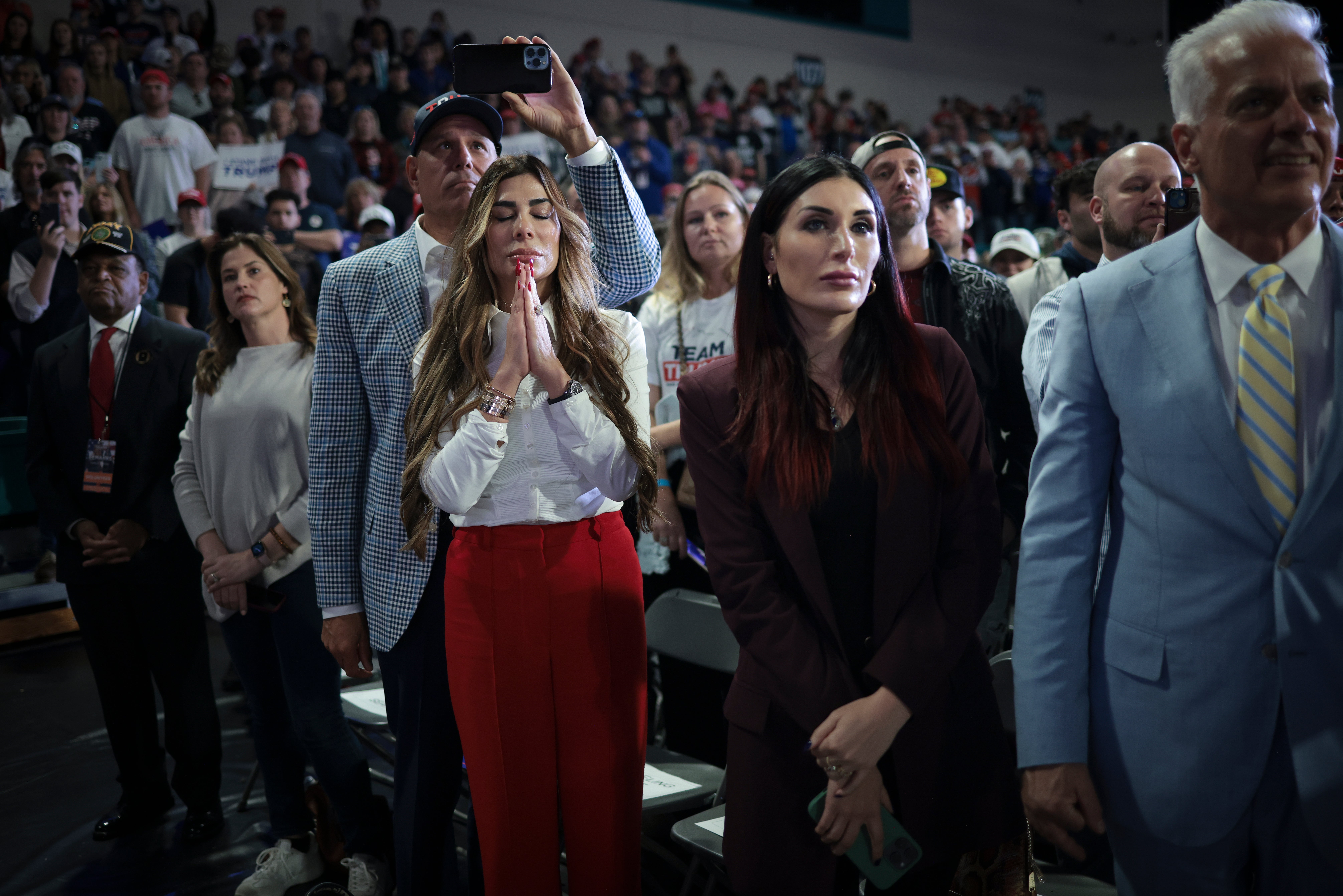 Trumpovi pristaše Siggy Flicker, lijevo i krajnje desna aktivistkinja Laura Loomer, slušaju kako republikanski predsjednički kandidatkinja i bivši predsjednik Donald Trump govori tijekom izbacivanja glasačkog skupa na Sveučilištu Coarol Carolina 10. veljače 2024. u Conwayu u Južnoj Karolini