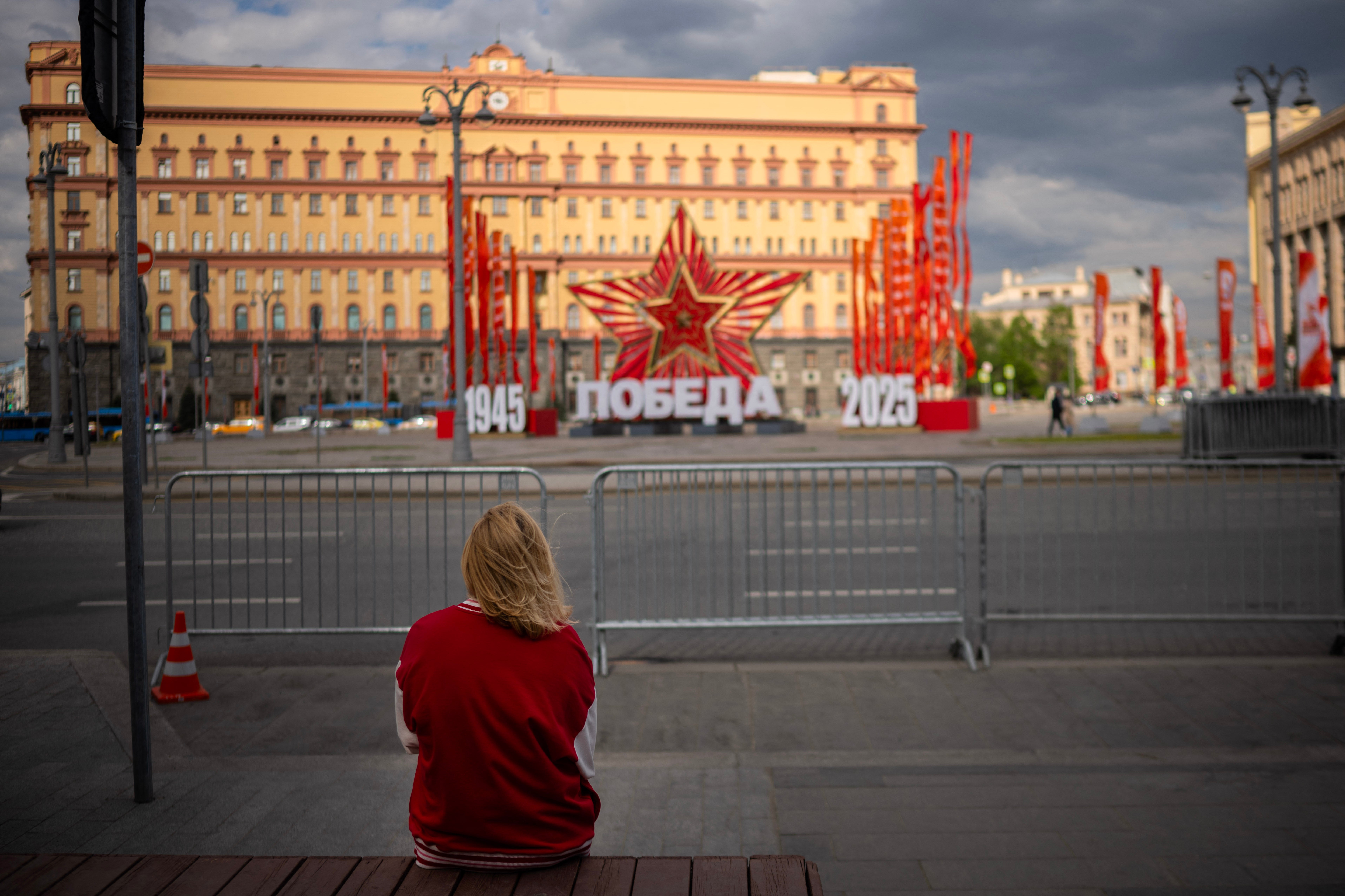 Žena sjedi na klupi u središnjoj Moskvi kao sjedište FSB sigurnosti (bivše KGB) i ukrase za Dan pobjede