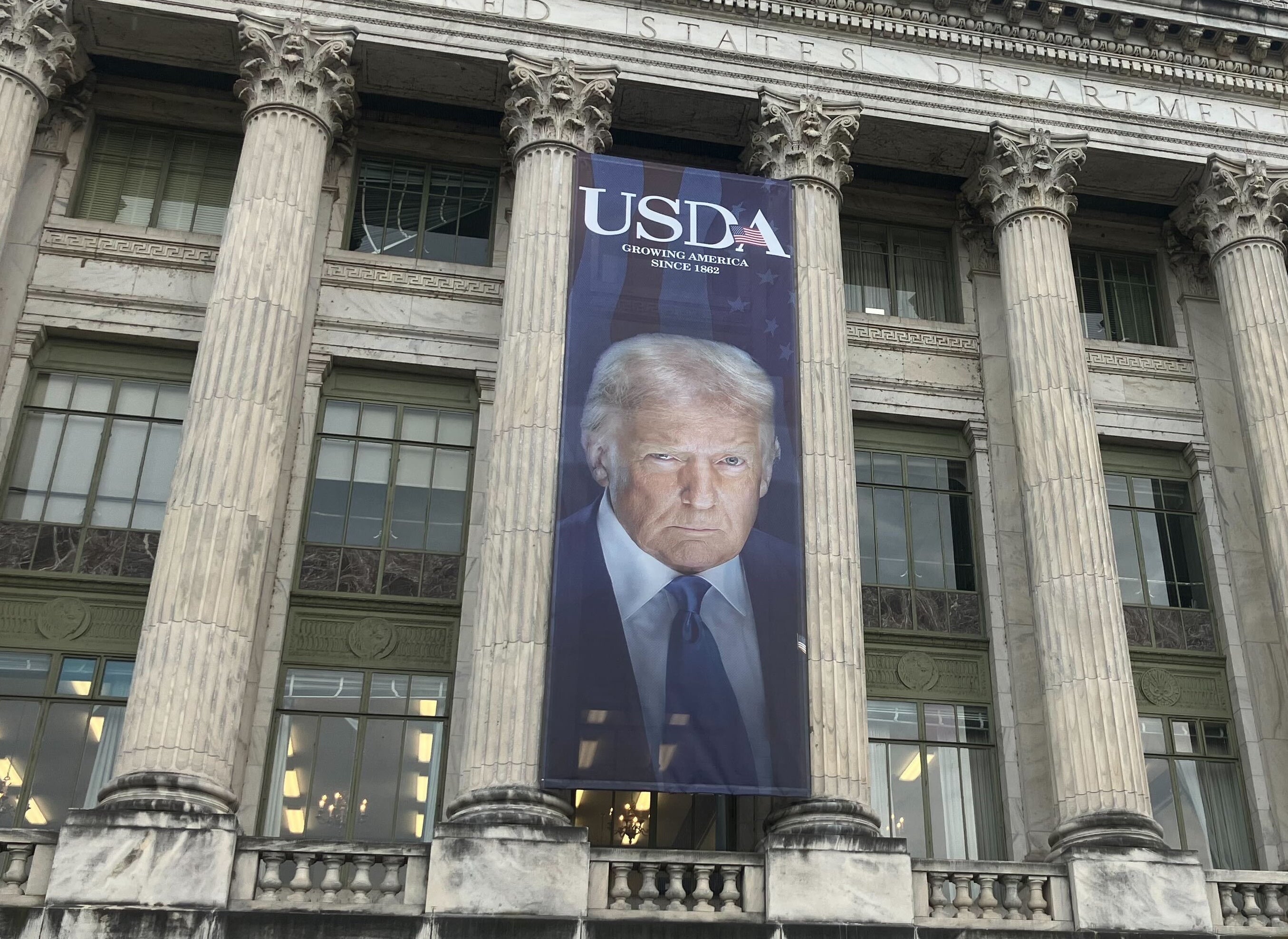 Veliki transparent s prikazom predsjednika Donalda Trumpa visi na fasadi američkog Ministarstva poljoprivrede u Washingtonu, DC