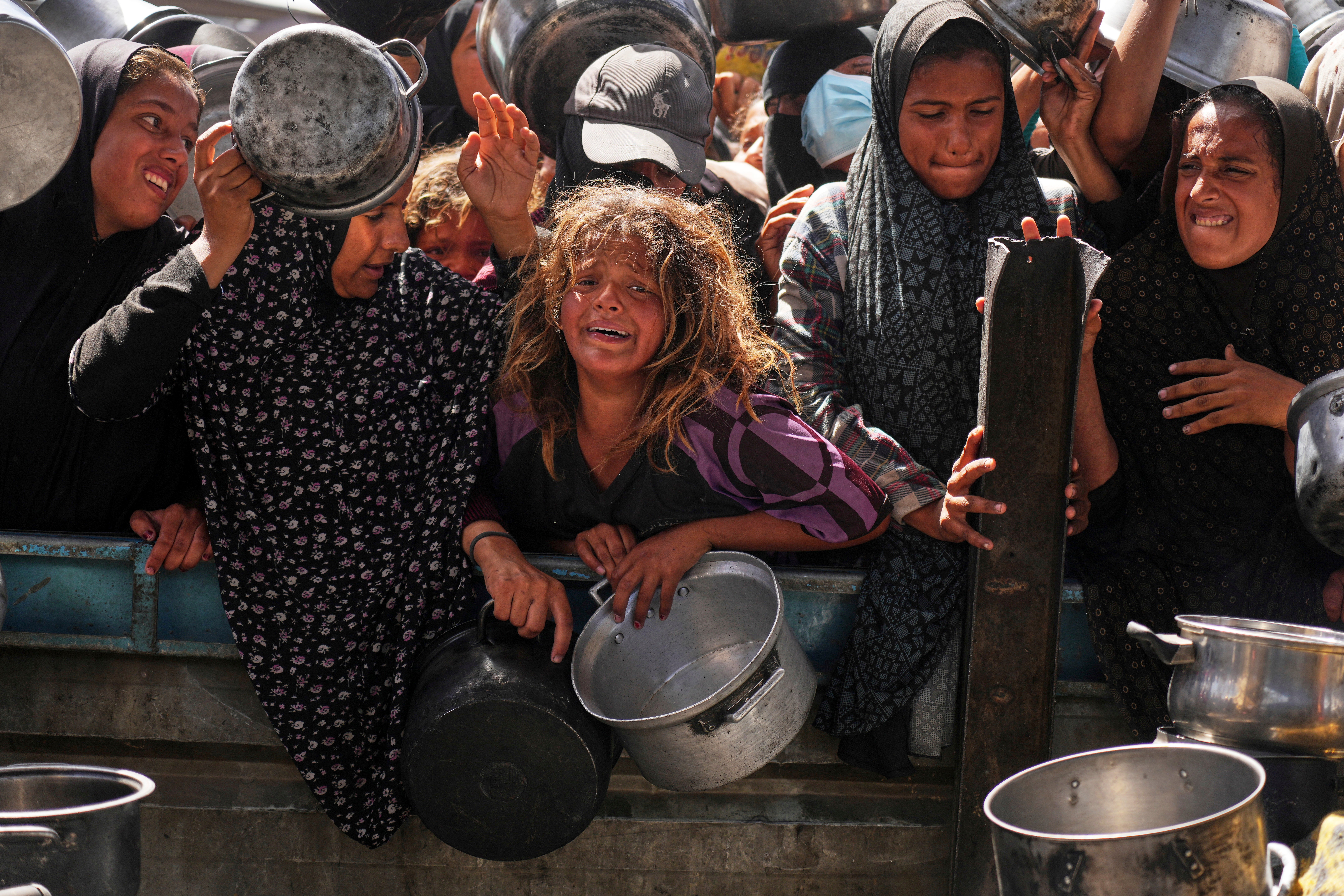 Palestinci se bore da dobiju doniranu hranu u kuhinji zajednice u Khanu Younisu, Gaza Strip