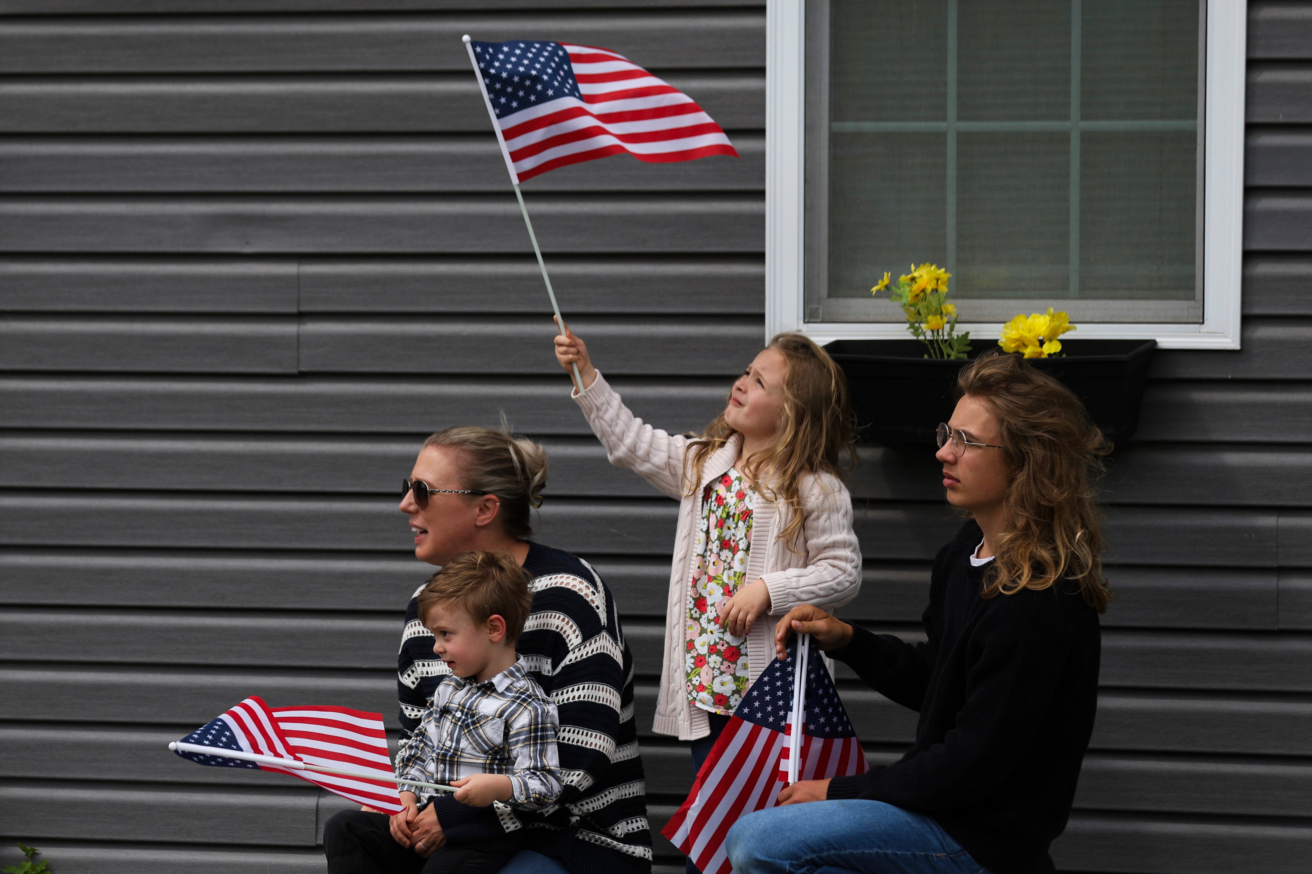 Fallon Haight, 5, centar, maše američkom zastavom dok čeka povorku koja je prevozila ostatke osoblja zračnih snaga američkih vojnih snaga Drugog svjetskog rata. Eugene Darrigan koji će proći, u subotu, 24. svibnja 2025., u Wappingers Fallsu, NY Darrigan je pokopan u svom rodnom gradu nakon što su njegovi posmrtni ostaci izvučeni iz bombaša iz Drugog svjetskog rata koji se srušio u vodu s obale Nove Gvineje 11. ožujka 1944. (AP Photo/Heather Khalifa)