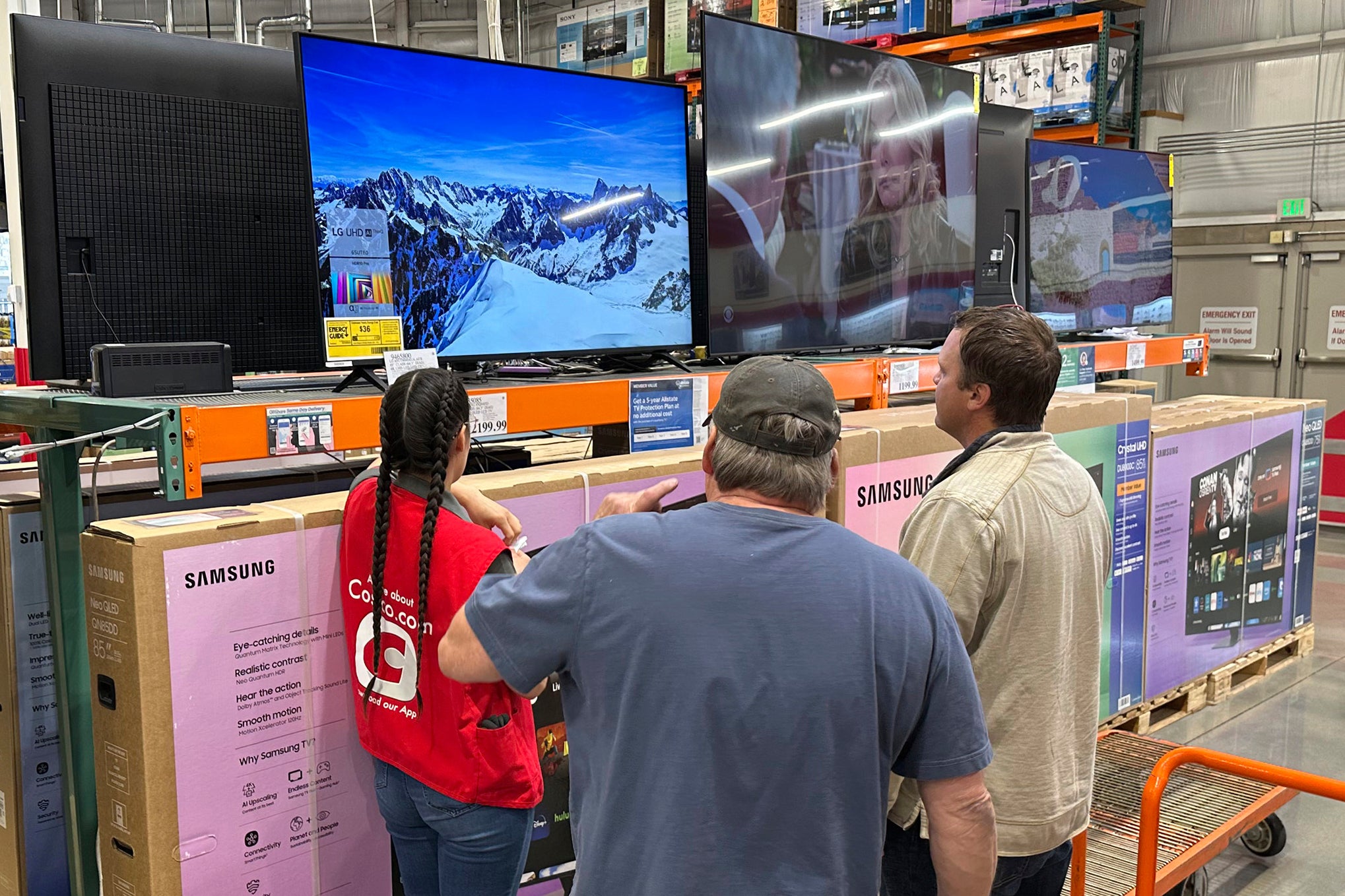 Kupci razmatraju televiziju s velikim ekranom uz pomoć prodajnog suradnika u skladištu Costco u četvrtak, 1. svibnja 2025., u Sheridan, Colorado (AP Photo/David Zalubowski)