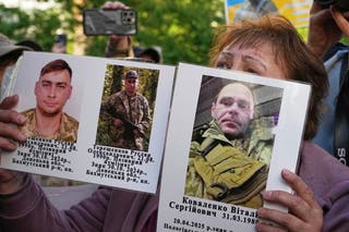 Ukrajinska žena drži fotografije vojnika u zatočeništvu tijekom razmjene ratnih zarobljenika između Rusije i Ukrajine, u regiji Chernyhiva