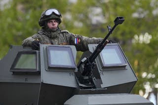 A Russian soldiers sits atop his military vehicle driving along Tverskaya street to attend a rehearsal for the Victory Day military parade in Moscow