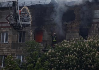 Vatrogasci rade na mjestu stambena zgrada u Kijevu koju je pogodio ruski bespilotni udar