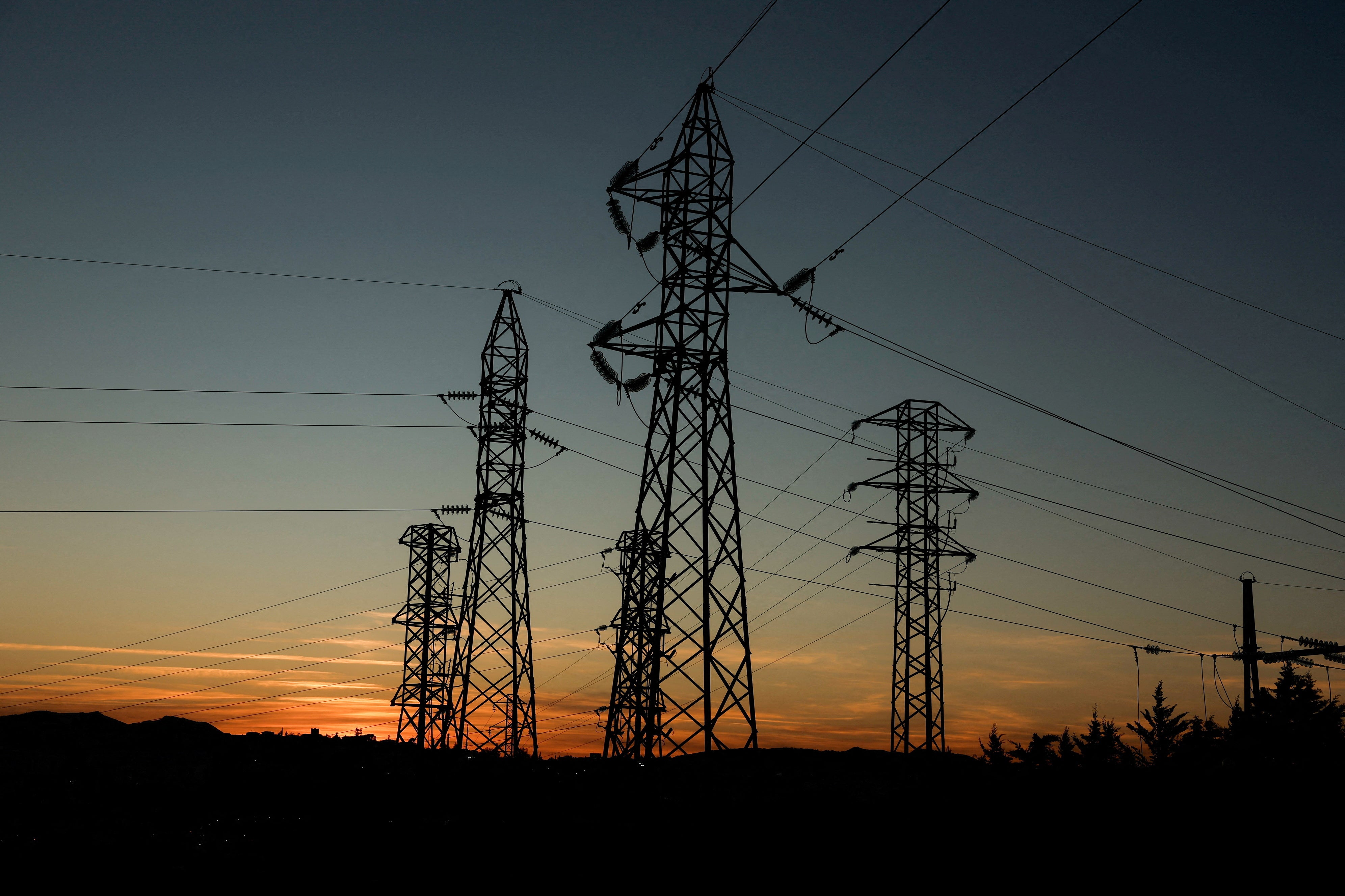 Povećanje struje koje povezuju stupove električne energije visoke napetosti vide se tijekom zalaska sunca u trafostanici električne energije na periferiji Ronde, tijekom zamračenja u gradu, Španjolska 28. travnja 2025. Reuters/Jon Nazca/File Photo