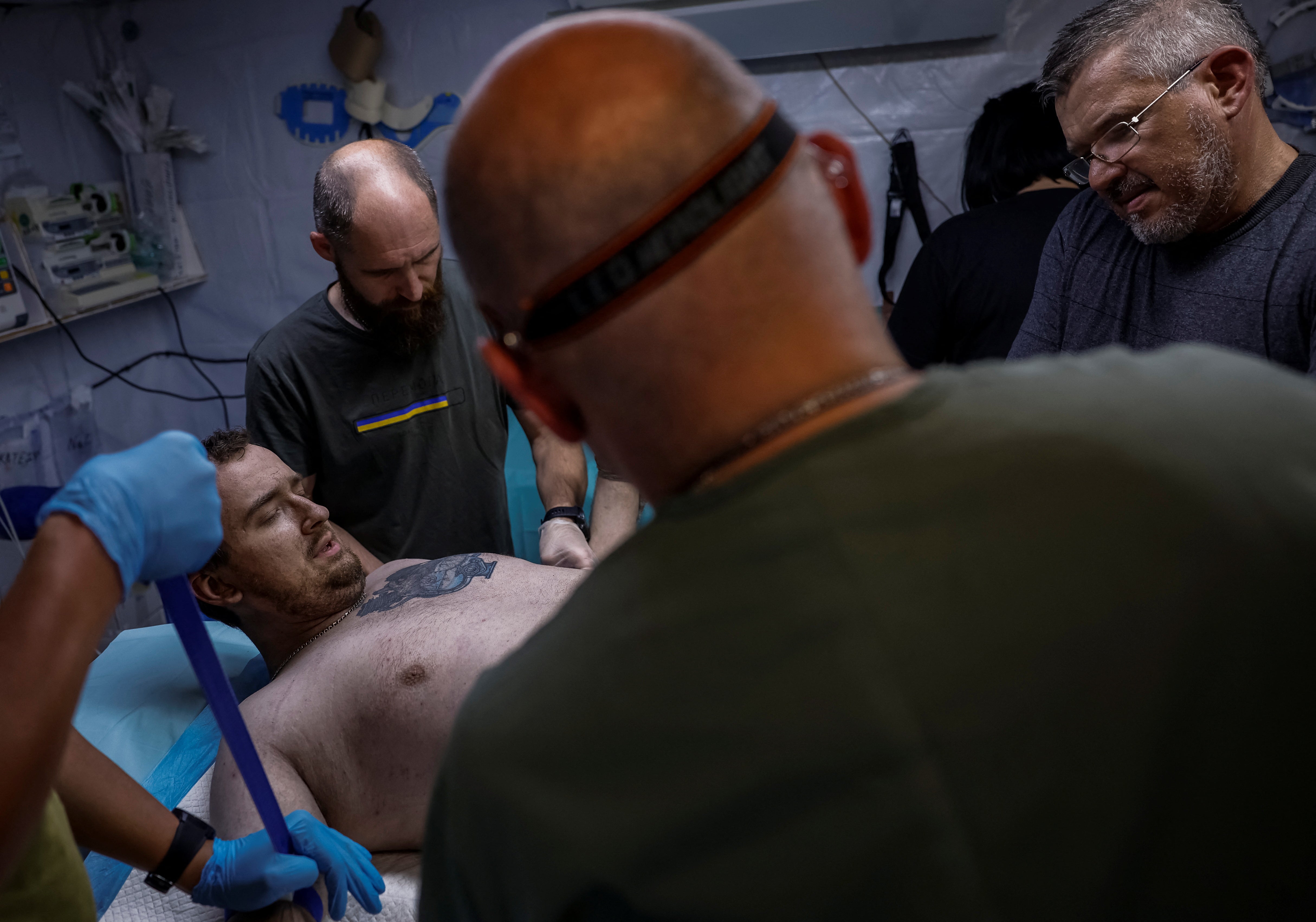Medicini pomažu Stanislavu, ranjeni ukrajinski vojnici 128. odvojene planine Transcarpatske brigade Oružanih snaga Ukrajine, u točki medicinske stabilizacije, usred napada Rusije na Ukrajinu, u regiji Zaporizhzhia, Ukrajina 9. svibnja, 2025.