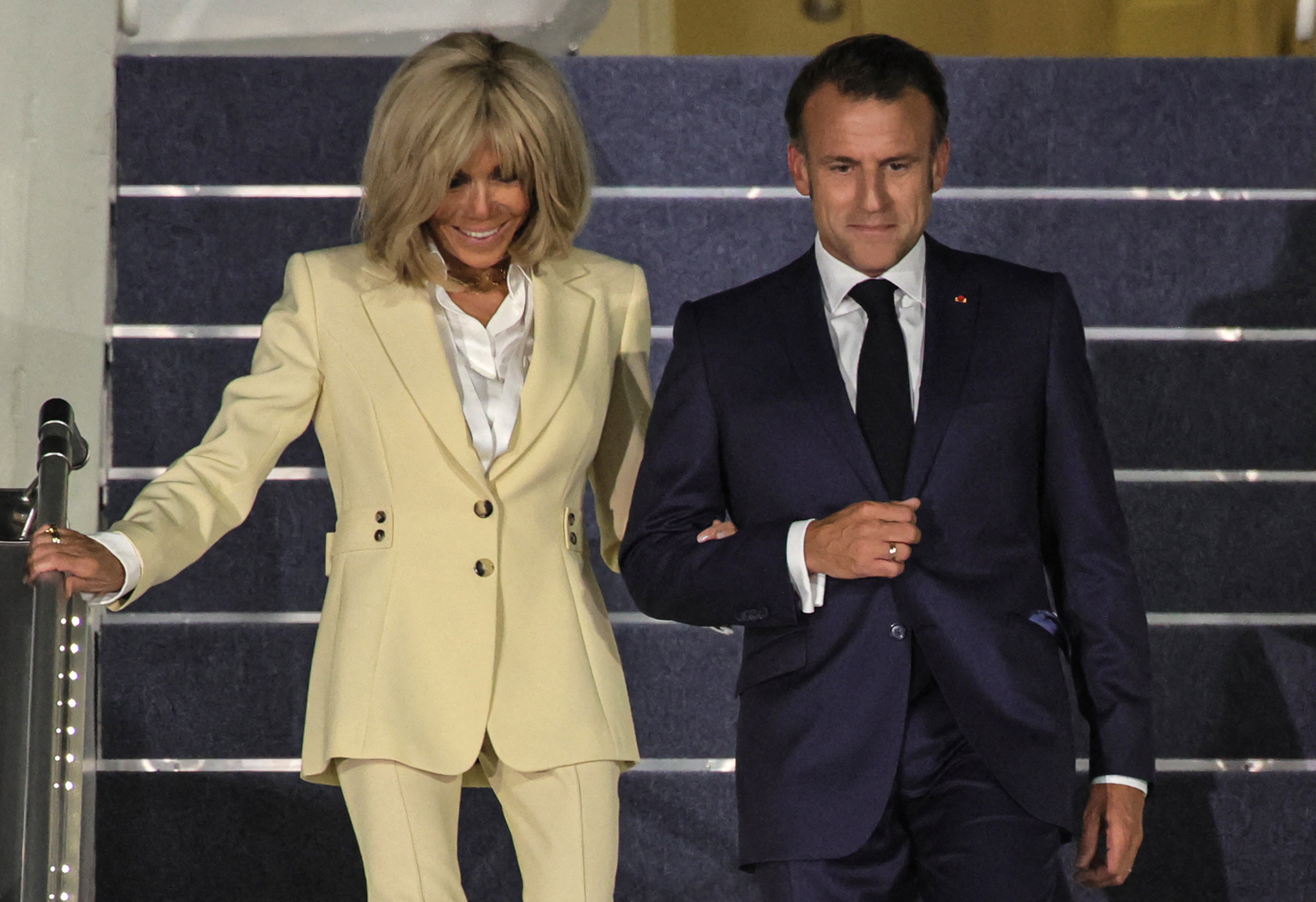 Emmanuel i Brigitte Macron prikazani su nasmiješenom rukom dok su koračali stepenicama francuskog predsjedničkog aviona u Indoneziji