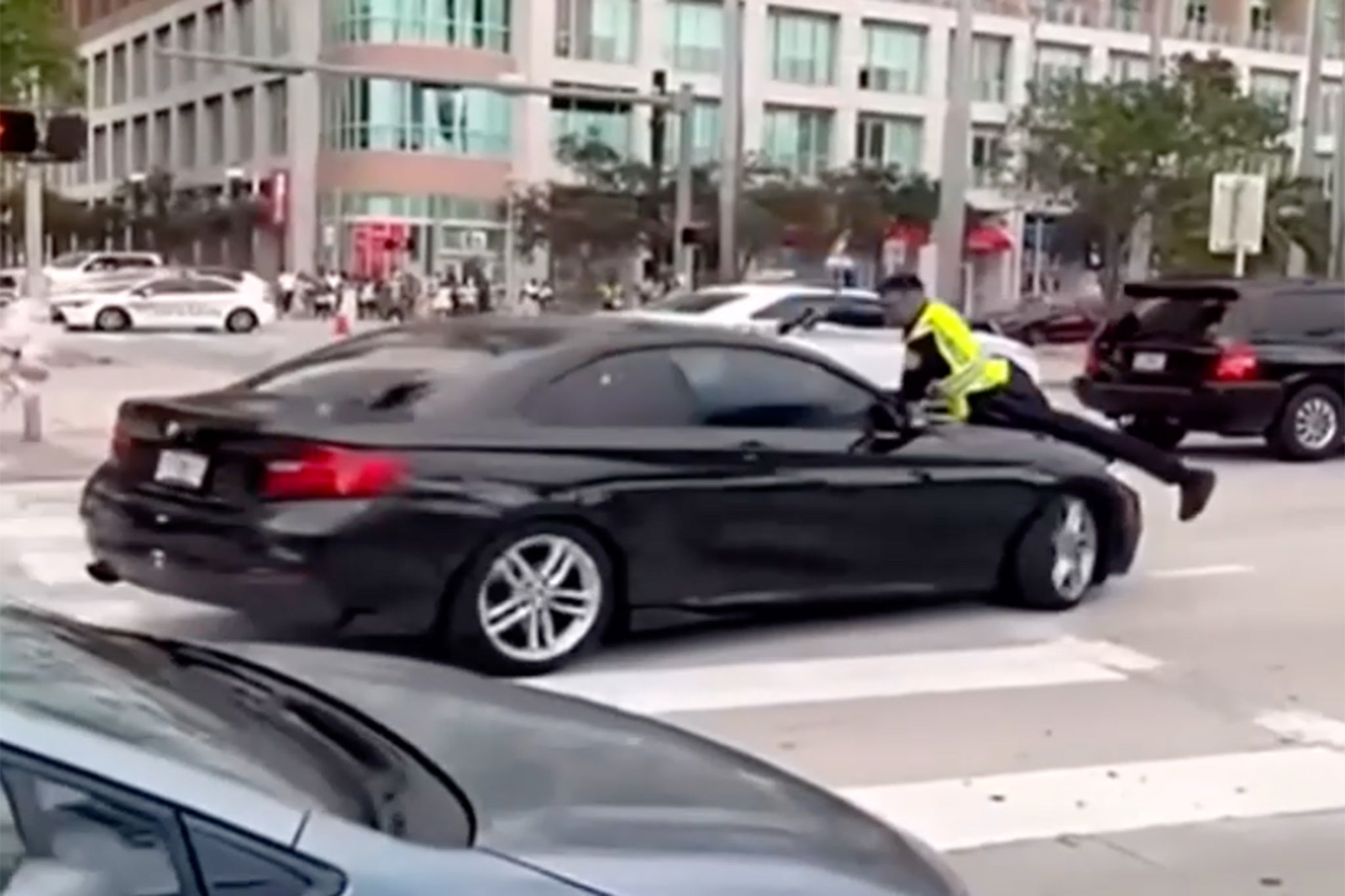 Video s mobitela dobivena u utorak lokalnim 10 vijesti prikazuje kaotične trenutke koji su doveli do policajca u Miamiju kako je otvorio vatru dok je bio na haubici automobila u blizini parka Bayfront