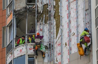 Radnici popravljaju oštećenu stambenu zgradu nakon ukrajinskog napada drona u Moskvi