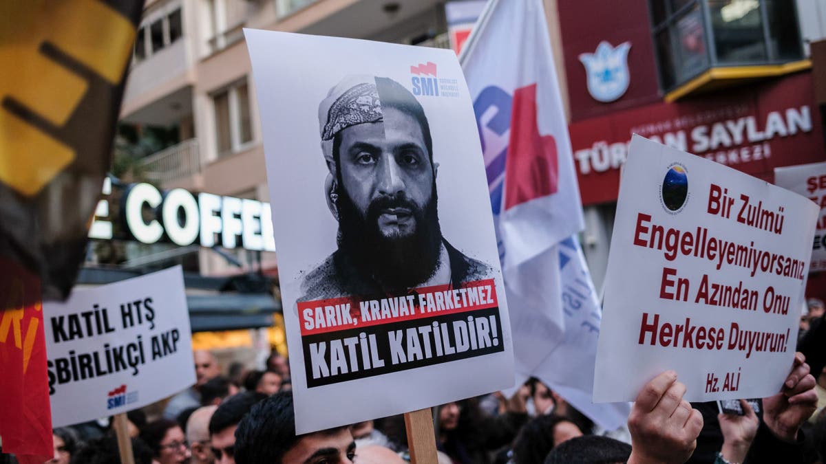 Prosvjednik drži plakatu s fotografijom Ahmeda al-Shara (Colani) i riječima "Nije važno da li nosi turban ili kravatu, ubojica je ubojica" Tijekom demonstracije.