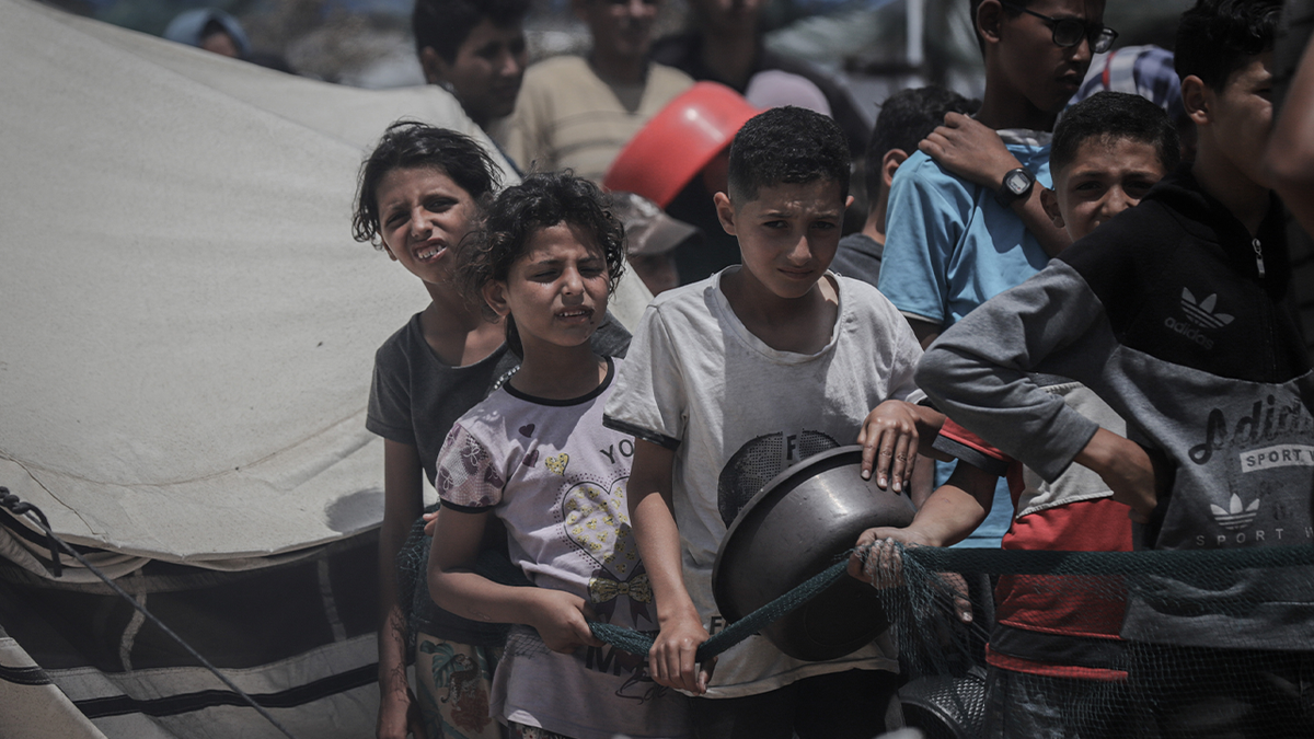 Namještena palestinska djeca čekaju da u utorak, 27. svibnja 2025. godine, dobiju besplatan obrok od dobrotvornog centra za distribuciju hrane u gradu Gaza, Sjeverna Gaza.