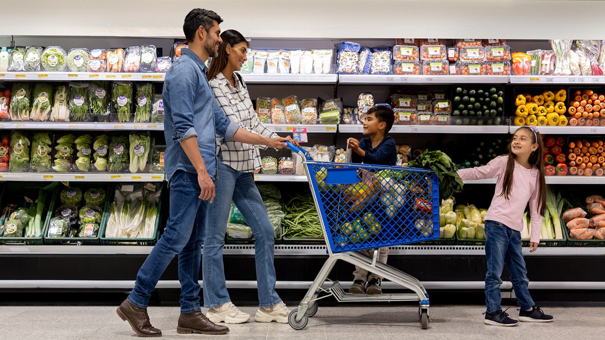 Obitelj koja koristi košaricu dok kupuje namirnice u supermarketu