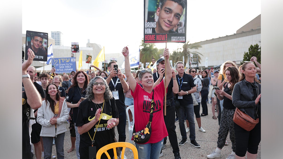 Ljudi navijaju i drže znakove na Trgu talaca u Tel Avivu uoči očekivanog izlaska Edan Alexandera.
