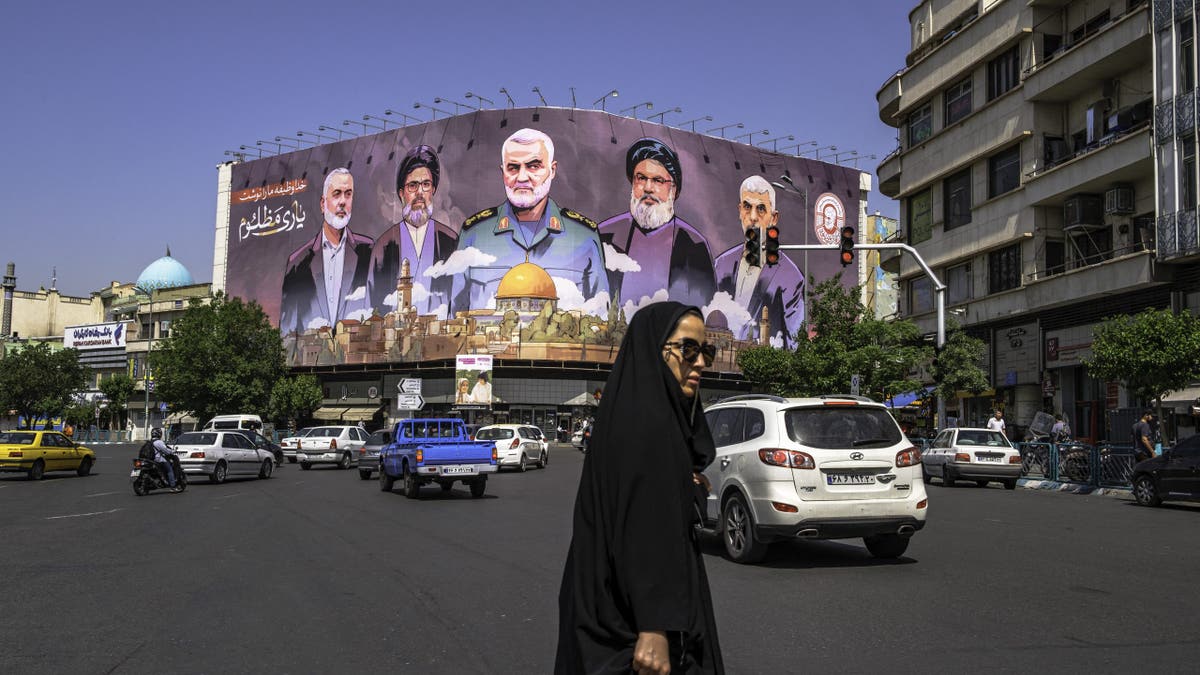 Ljudi se kreću pored velikog transparenta s portretima ubijenih vođa iz Iran, usklađenih oružanih skupina, uključujući vođu Hamasa Yahya Sinwar, vođu Hezbollaha Hassana Nasrallaha i iranskog zapovjednika Qasem Soleimani, u središnjem Teheranu, Iran, 1. svibnja 2025.