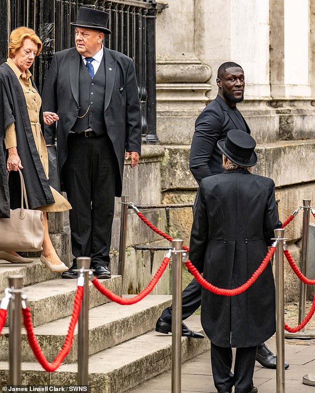 Stormzy se pridružuje sir Simonu Russellu Bealeu, profesorici Angela Davis, Lady Arden iz Heswalla, Dame Katherine Grainger, sir Oliver Hart, profesor Maria Leptin i sir John Rutter u primanju nagrada