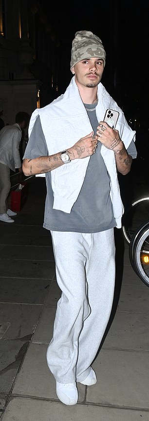 Tenisač koji se nadao, ležerno je bio obučen u sive dno trzaja uparene s majicom i kapuljačom navučenom preko ramena