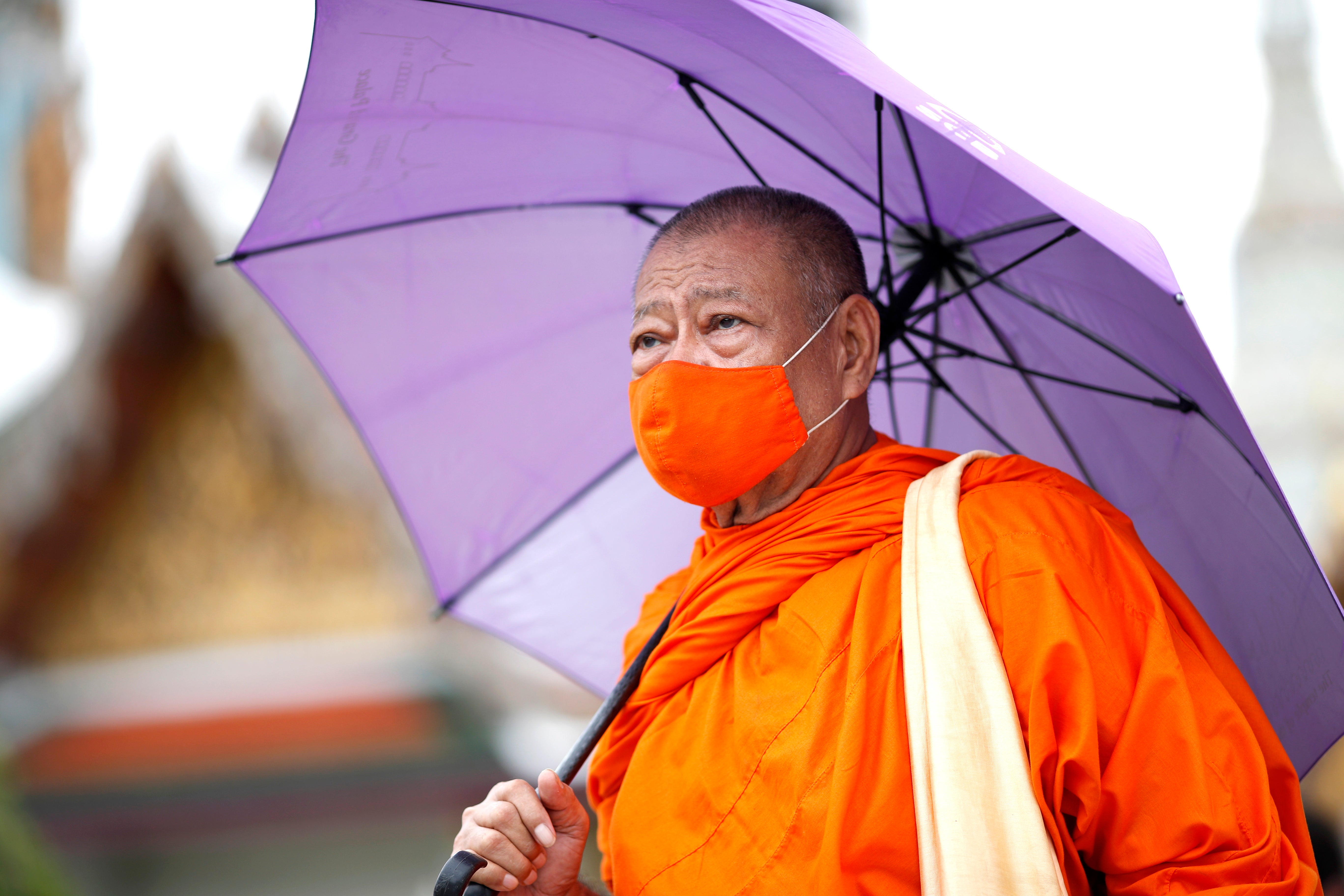 Monah nosi masku za lice u hramu smaragdne Bude u Bangkoku