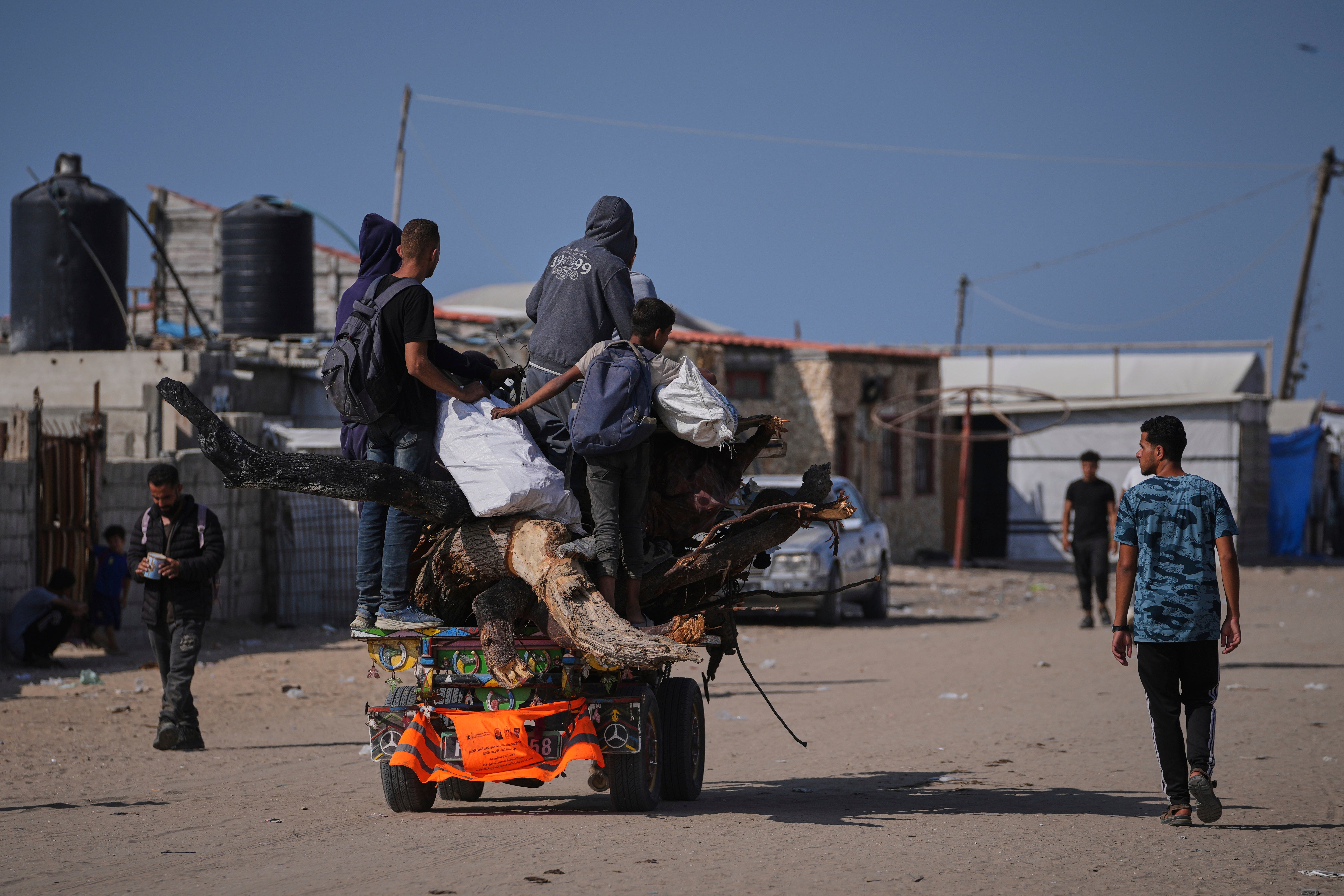 Raseljeni Palestinci nose drva i druge predmete u Rafah