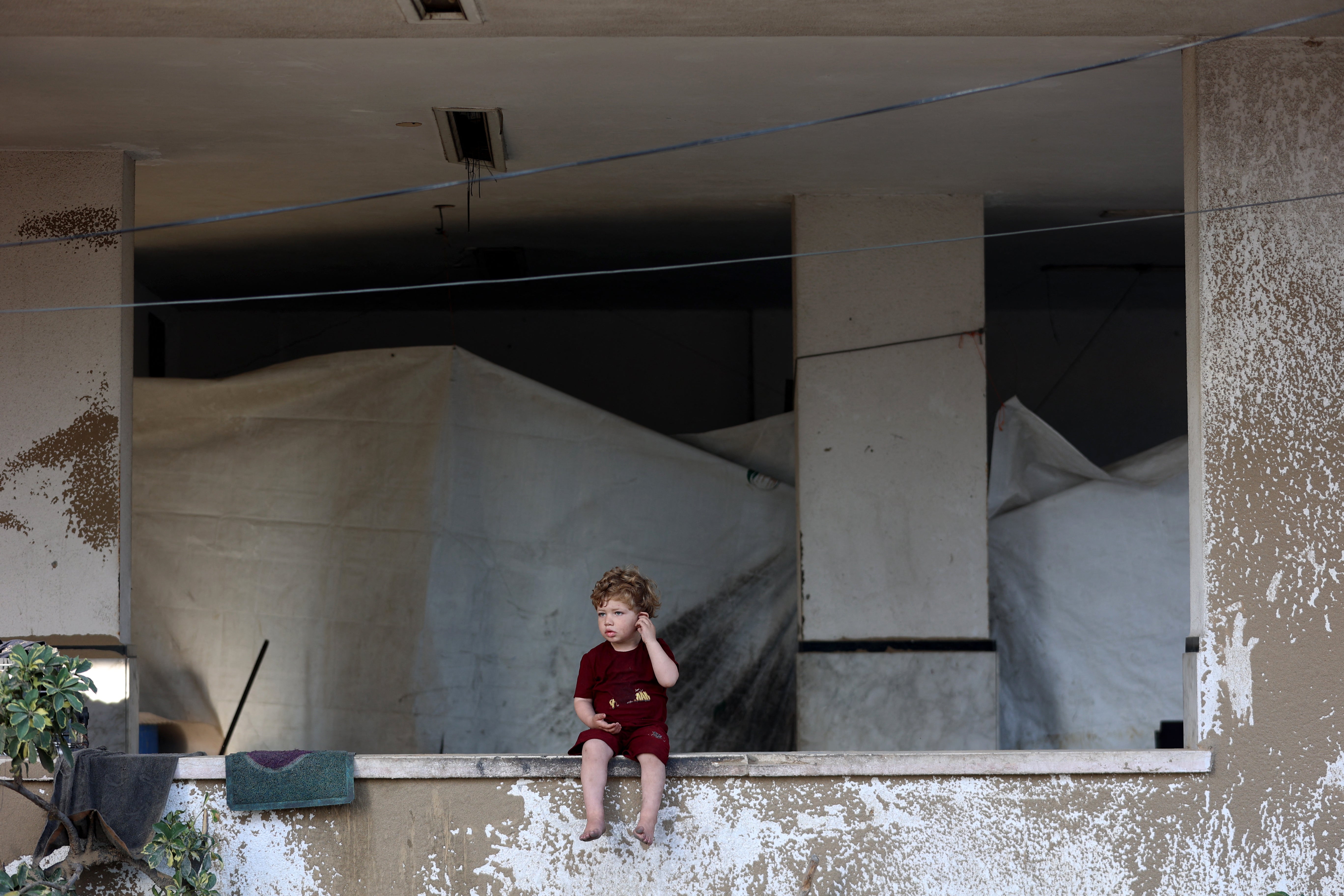 Sklonište za cerados postavljeno je u zgradi dok palestinsko dijete sjedi na polici nakon što je izraelska vojska ciljala na šatore raseljenih ljudi u sjevernom Al-Rimal susjedstvu grada Gaze 28. lipnja 2025. godine.