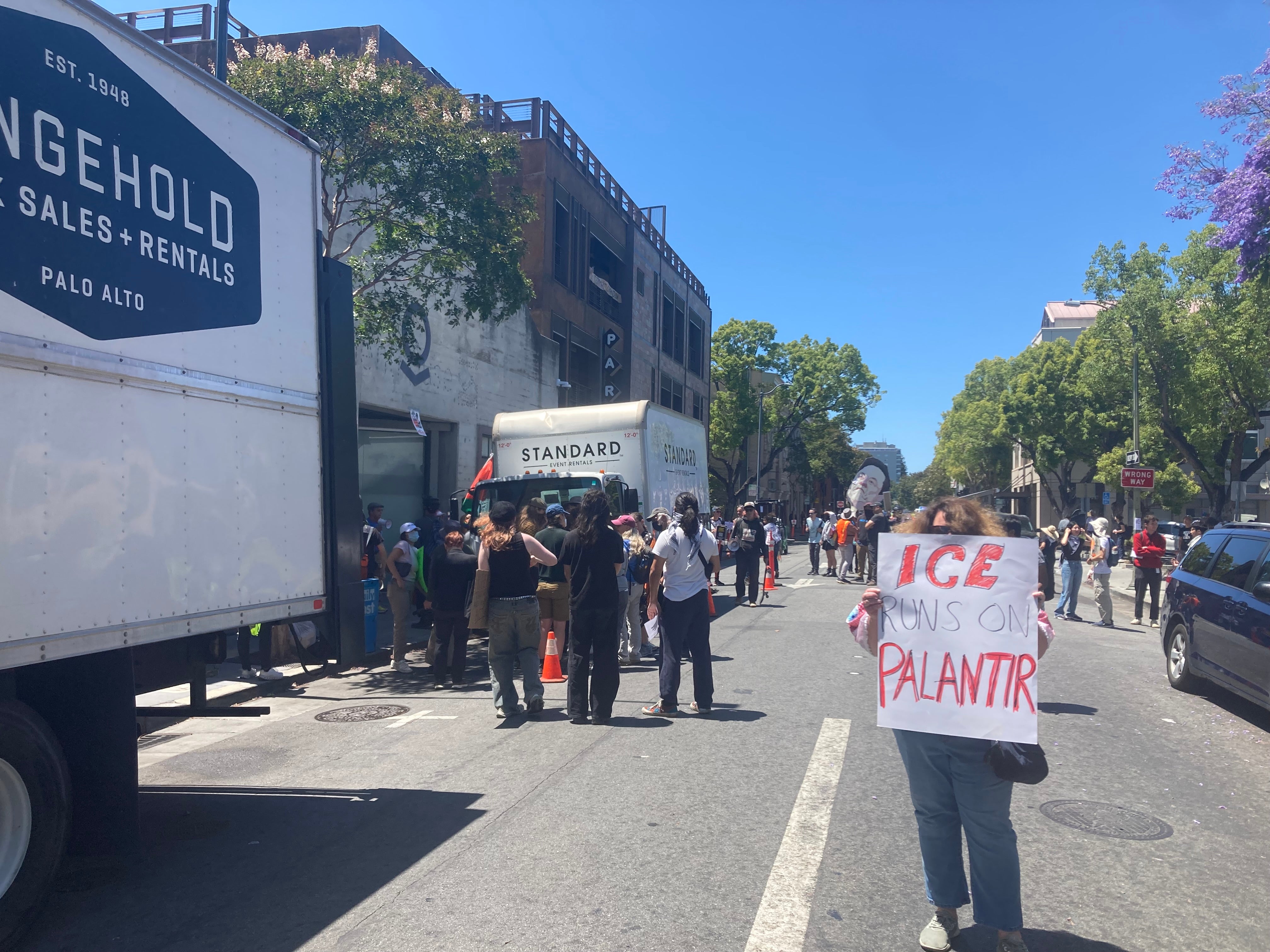 Prosvjednici se okupljaju izvan navodne lokacije konferencije za razvojne programere Palantir, zajedno s zbunjenim vozačima isporuke