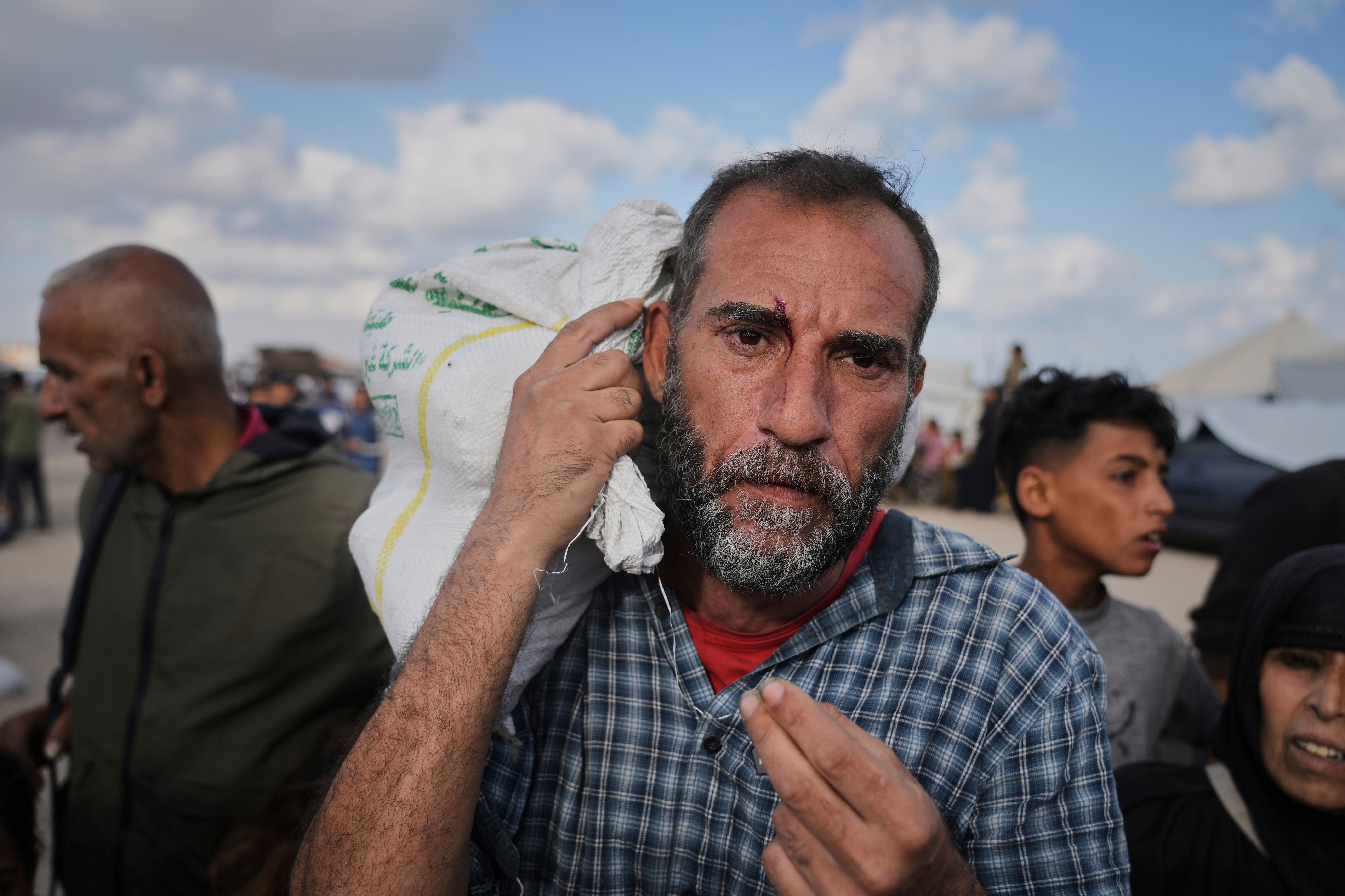Palestinci nose torbe ispunjene hranom i humanitarnom pomoći koju je pružila Humanitarna zaklada u Gazi u Khanu Younisu prije nego što se operacije ugasi