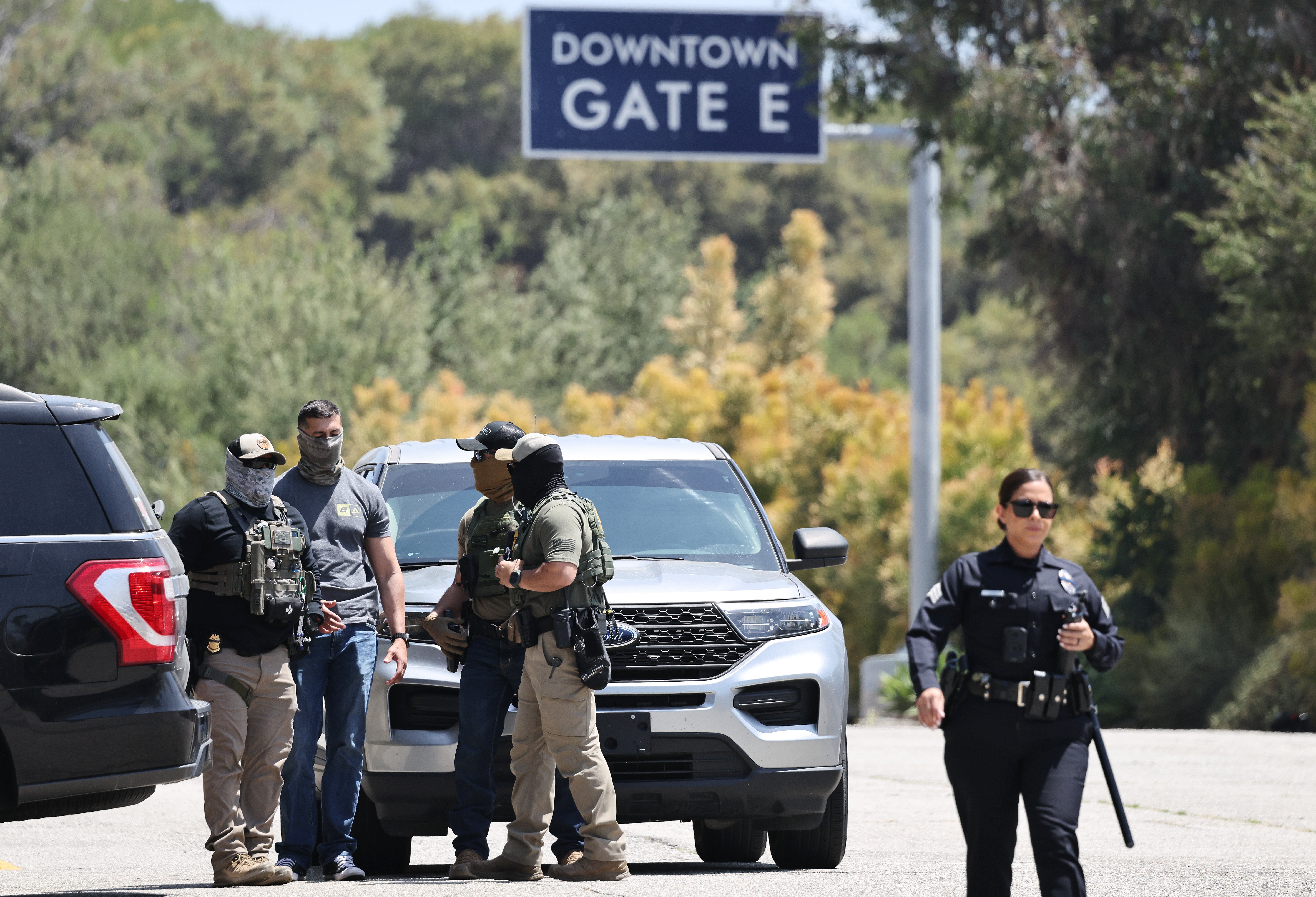 Policajac LAPD -a hoda u blizini maskiranih saveznih agenata upriličen ispred vrata stadiona Dodger 19. lipnja