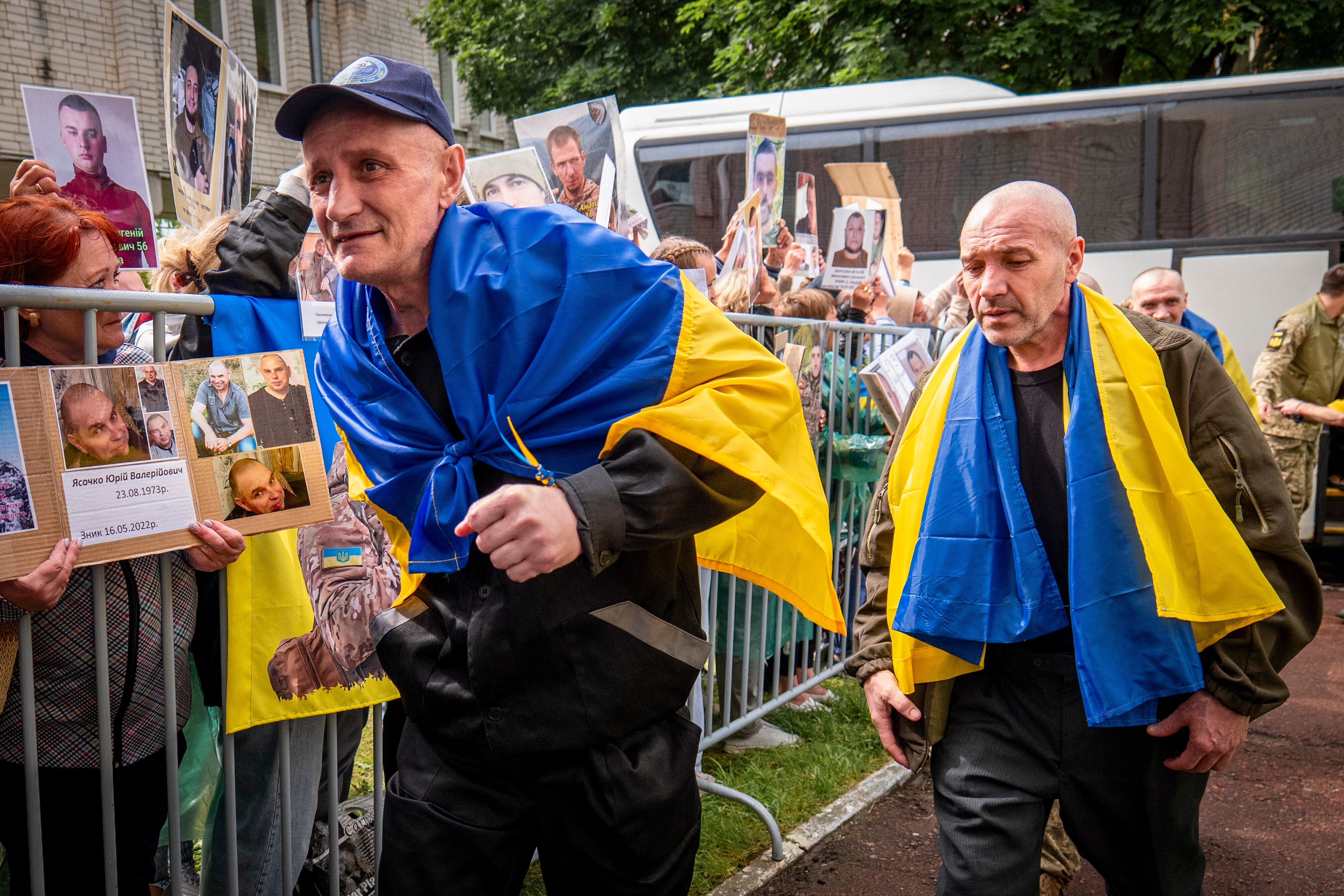 Oslobođeni Ukrajinski vojnici koji su stigli nakon razmjene zarobljenika s Rusijom šetaju Ukrajincima koji drže fotografije svoje nestale rodbine u regiji Chernyhiv, Ukrajina, petak, 20. lipnja 2025. (AP Photo/Dan Bashakov)