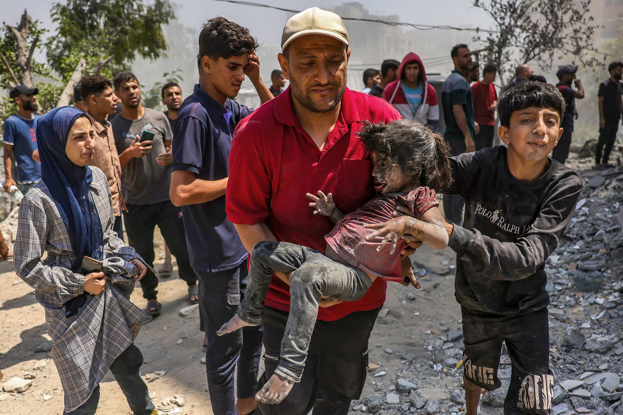 Palestinski muškarac nosi dijete izvučeno iz ruševine kuće obitelji Shaheen koja je bila na meti izraelskog štrajka u susjedstvu Saftawi, zapadno od Jabalia, u Strip u sjevernoj Gazi