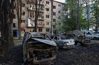 Pogled prikazuje automobile i stambenu zgradu oštećenu ruskim štrajkom drona, uslijed ruskog napada na Ukrajinu, u Harkivu, Ukrajina, 11. lipnja 2025.