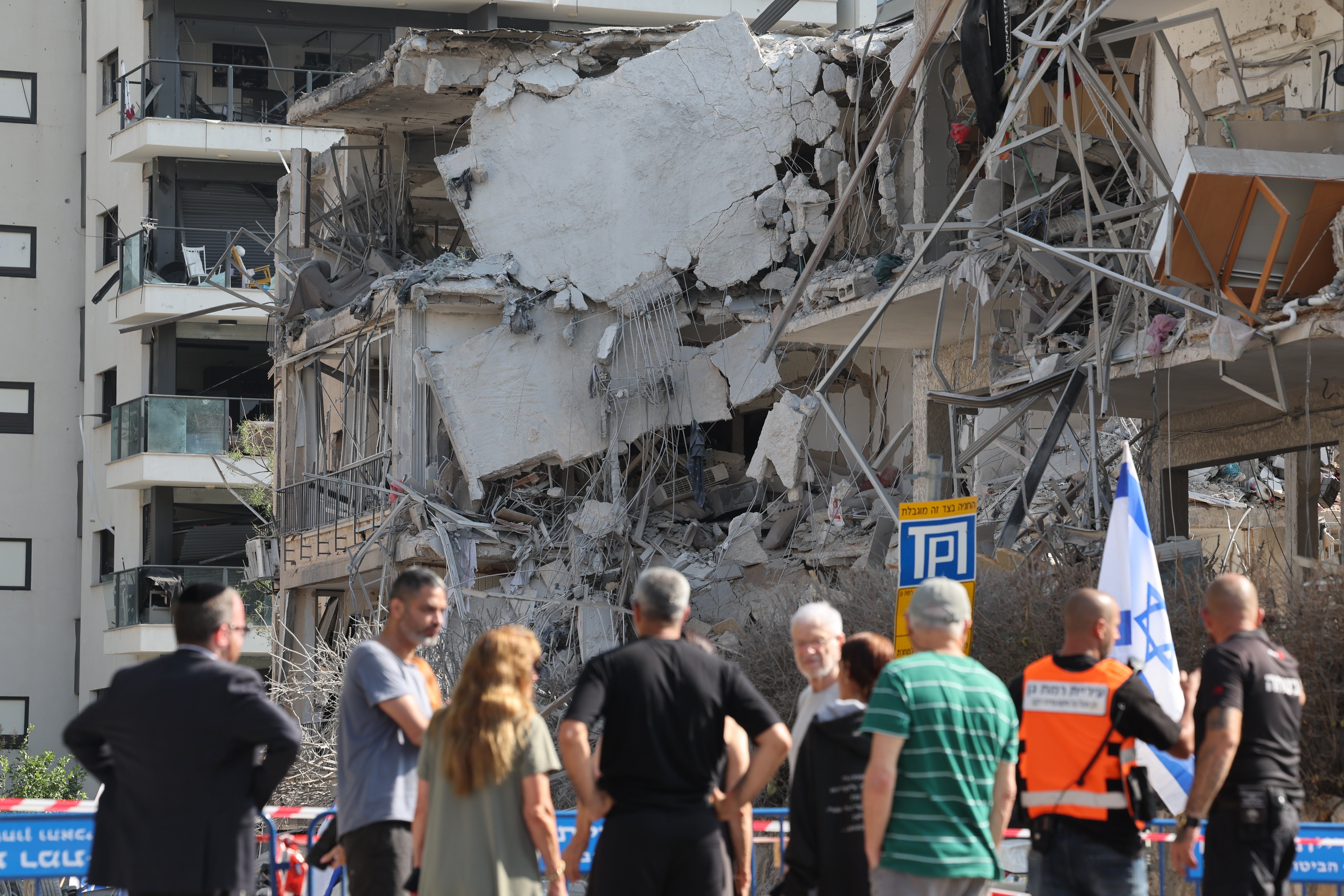 Ljudi pregledavaju oštećenu stambenu zgradu nakon balističkog raketnog udara u Ramat Ganu, u blizini Tel Aviva, Izrael,