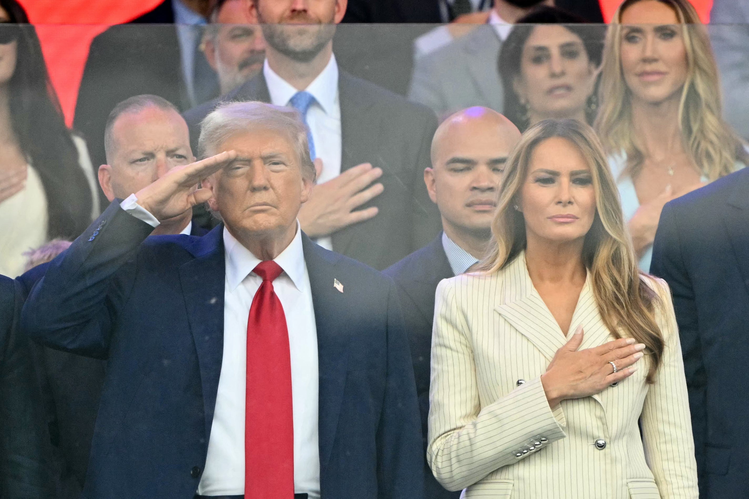 Spremnici kotrljaju Trump i prvu damu Melania Trump dok gledaju paradu sa tribina na mračnoj i oblačnoj večeri u Washingtonu, DC