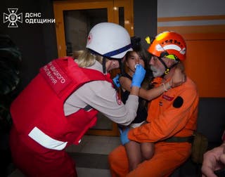 Paramedici pomažu djevojci na mjestu stambene zgrade koju je pogodio ruski bespilotni štrajk u Odesi, Ukrajina