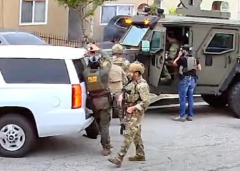 Snažno naoružani savezni agenti pušu vrata od kuće Sumnjine. Nije bio tamo – ali djevojka i djeca su bili