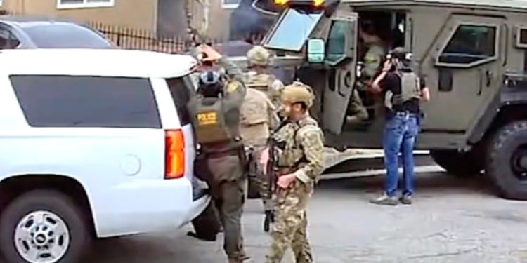 Snažno naoružani savezni agenti pušu vrata od kuće Sumnjine. Nije bio tamo – ali djevojka i djeca su bili