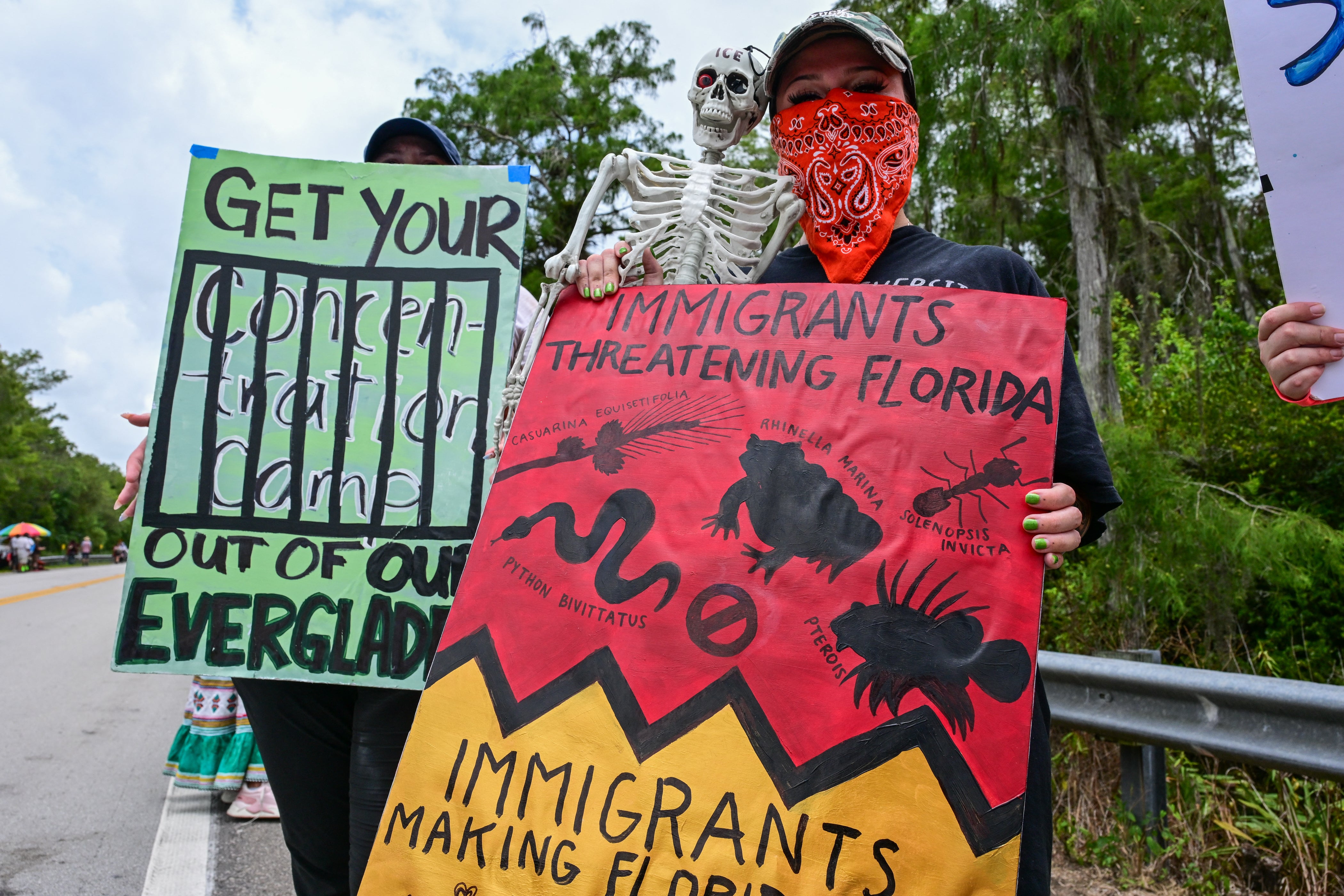 Demonstranti drže znakove dok protestiraju u izgradnji imigrantskog pritvorskog centra nazvanog 