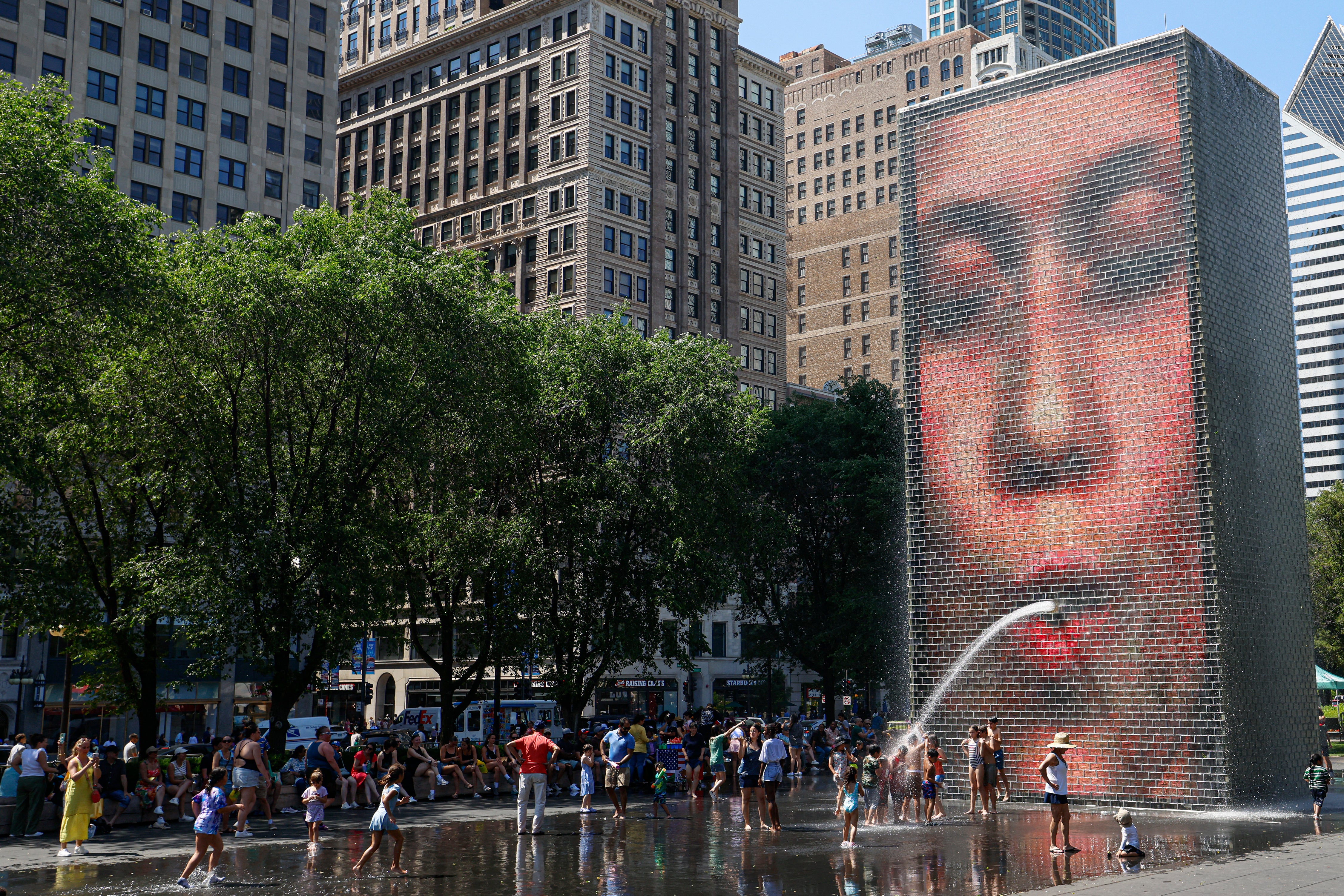 Ljudi se hlade u fontani krune u Millennium Parku dok su se temperature popele na preko 95 stupnjeva Fahrenheita (35 stupnjeva Celzija), u Chicagu