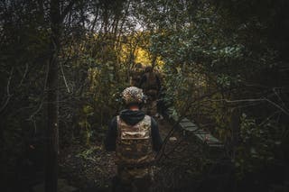 Vojnici koji se kreću kroz šumu do 122 mm Houditzer 2A18, a ukrajinske snage s 117. teritorijalnom obrambenom brigadom upravljaju artiljerijskim položajem u regiji Sumy u Ukrajini