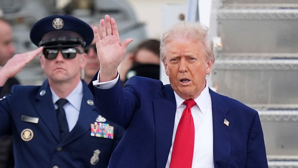 Donald Trump u Miamiju mahajući, službenik zrakoplovstva pozdravlja iza njega