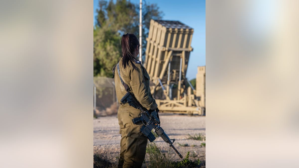 Ženski vojnik stoji uz bateriju željezne kupole. Žene čine polovicu svih operatora Iron Dome i proširuju svoju uslugu za godinu dana na tri godine.