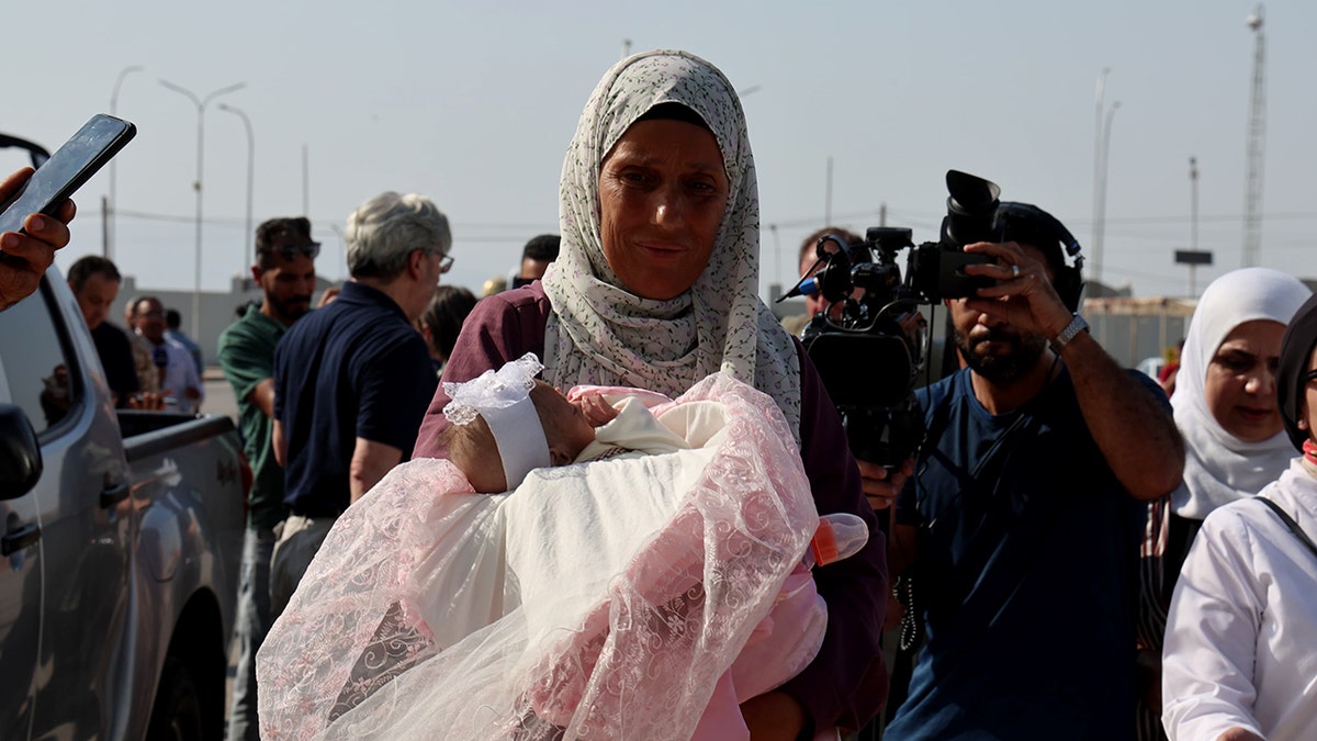 Palestinska žena nosi dijete ispred evakuacije iz pojasa Gaze putem Jordanskog medicinskog koridora.