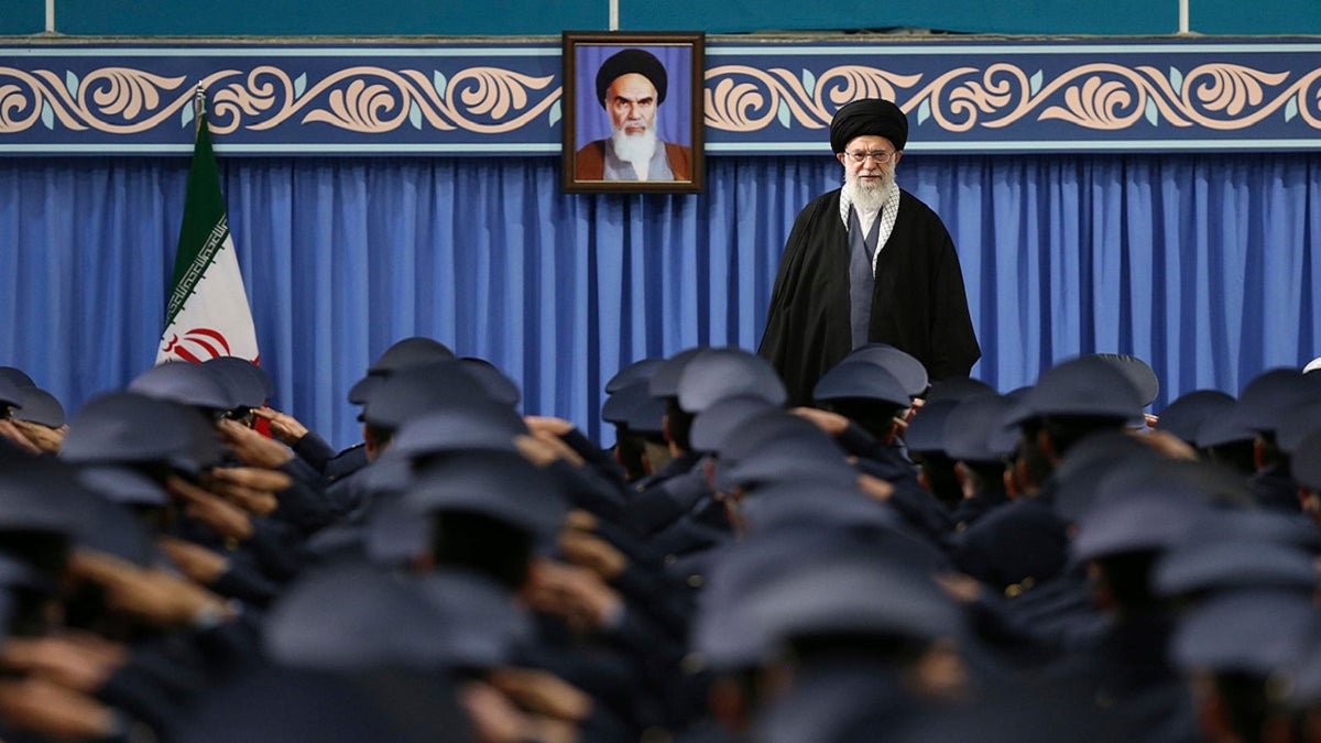 Na ovoj slici koju je objavila službena web stranica Ureda iranskog vrhovnog vođe, vrhovni vođa Ayatollah Ali Khamenei stoji kao vojni zrakoplovne snage i osoblje zračne obrane na početku njihovog sastanka u Teheranu u Iranu, u četvrtak, 8. veljače 2018., portret kasnog revolucionarnog utemelja Ayatollah Khomeini. (Ured iranskog vrhovnog vođu putem AP)