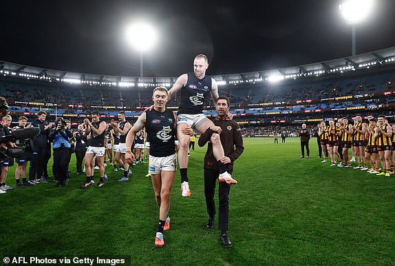 MELBOURNE, AUSTRALIA - JULY 24: Sam Docherty of the Blues is chaired from the field after his final game by Patrick Cripps of the Blues (left) and Kade Simpson during the 2025 AFL Round 20 match between the Hawthorn Hawks and the Carlton Blues at the Melbourne Cricket Ground on July 24, 2025 in Melbourne, Australia. (Photo by Michael Willson/AFL Photos via Getty Images)