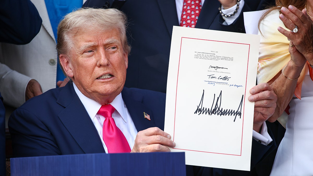 Predsjednik Trump pokazuje potpisan