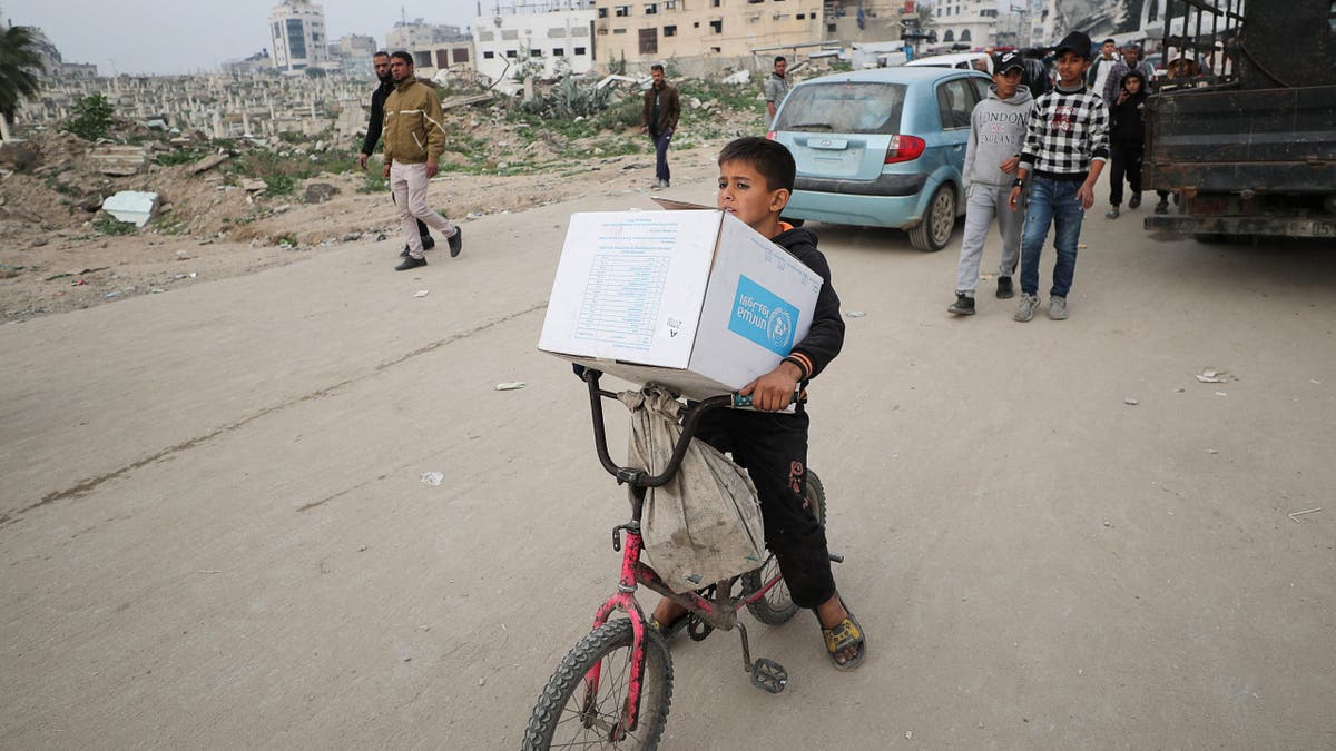Palestinski dječak nosi kutiju za pomoć u UNRWA -u, usred primirja između Hamasa i Izraela, u gradu Gazi, 3. veljače 2025. godine.