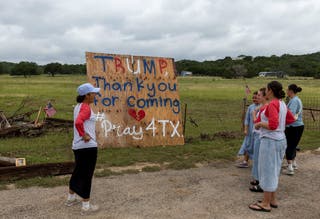 Volonteri koji pomažu mještanima da očiste krhotine iz svojih kuća, stavljaju transparent na glavnu cestu ispred američkog predsjednika Donalda Trumpa u Teksas u obilazak područja pogođenih smrtonosnim poplavama u lovu, u Teksasu