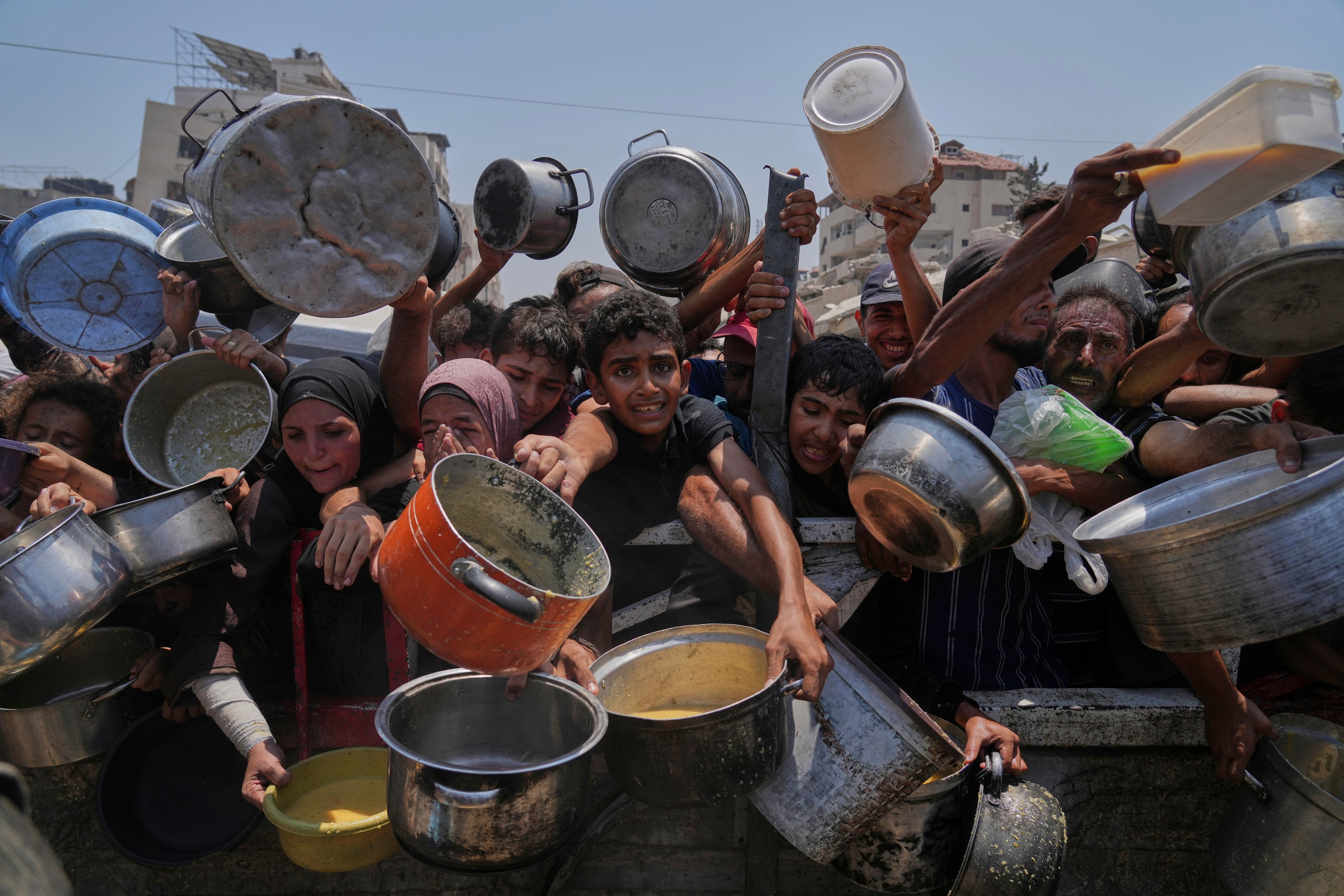Palestinci se bore da dobiju doniranu hranu u kuhinji u zajednici, u gradu Gaza