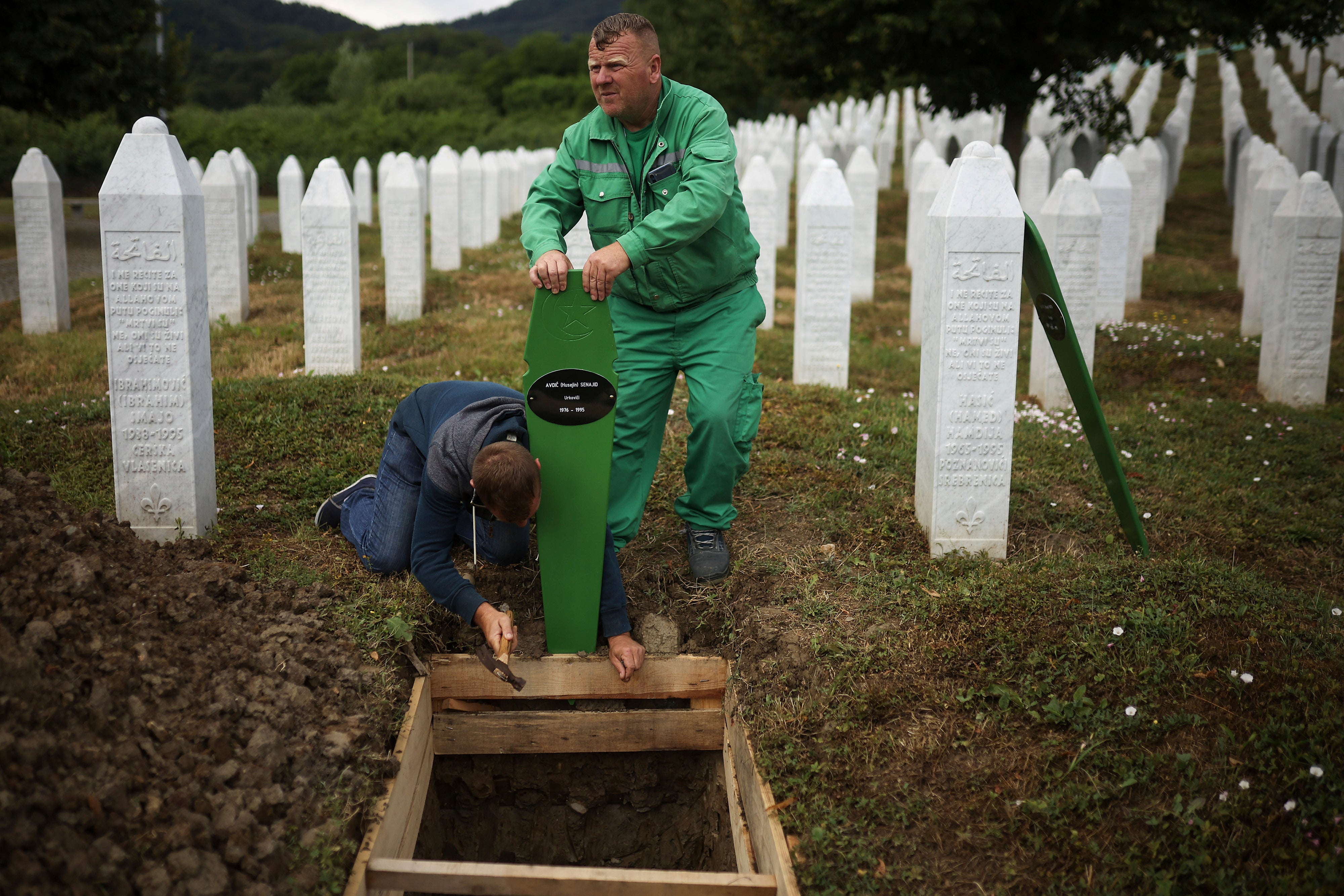 Radnici groblja pripremaju grobove za masovni sahrana od sedam novootkrivenih žrtava genocida Srebrenice iz 1995. godine u Potocariju, Bosna