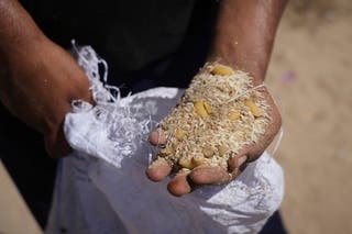 Palestinski čovjek prikazuje sadržaj paketa za humanitarne pomoći nakon što su bili ubačeni u Zawaidu, u središnjoj traci Gaze